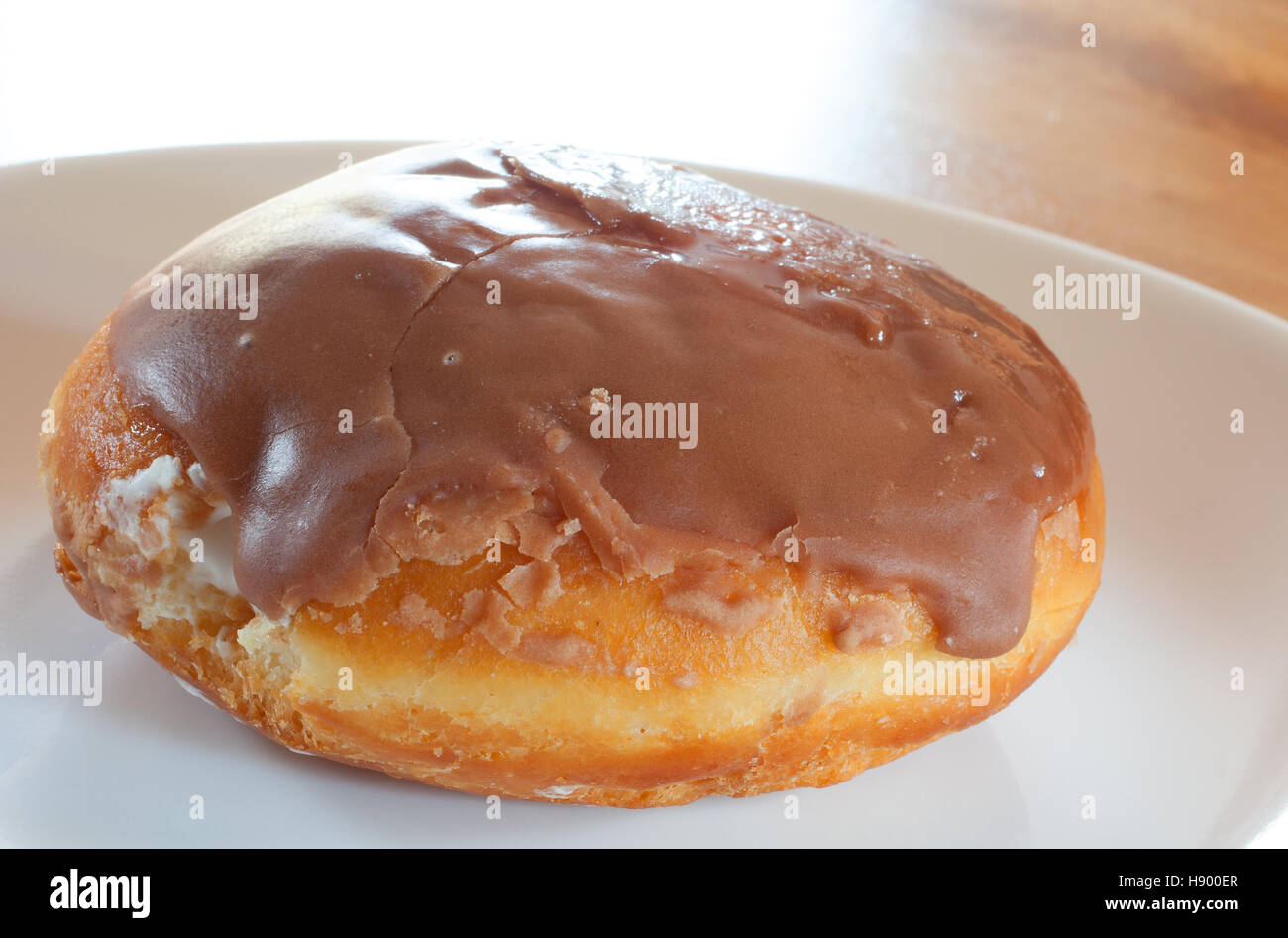 Einzigen Donut mit Schokolade Zuckerguss und Creme-Füllung Stockfoto