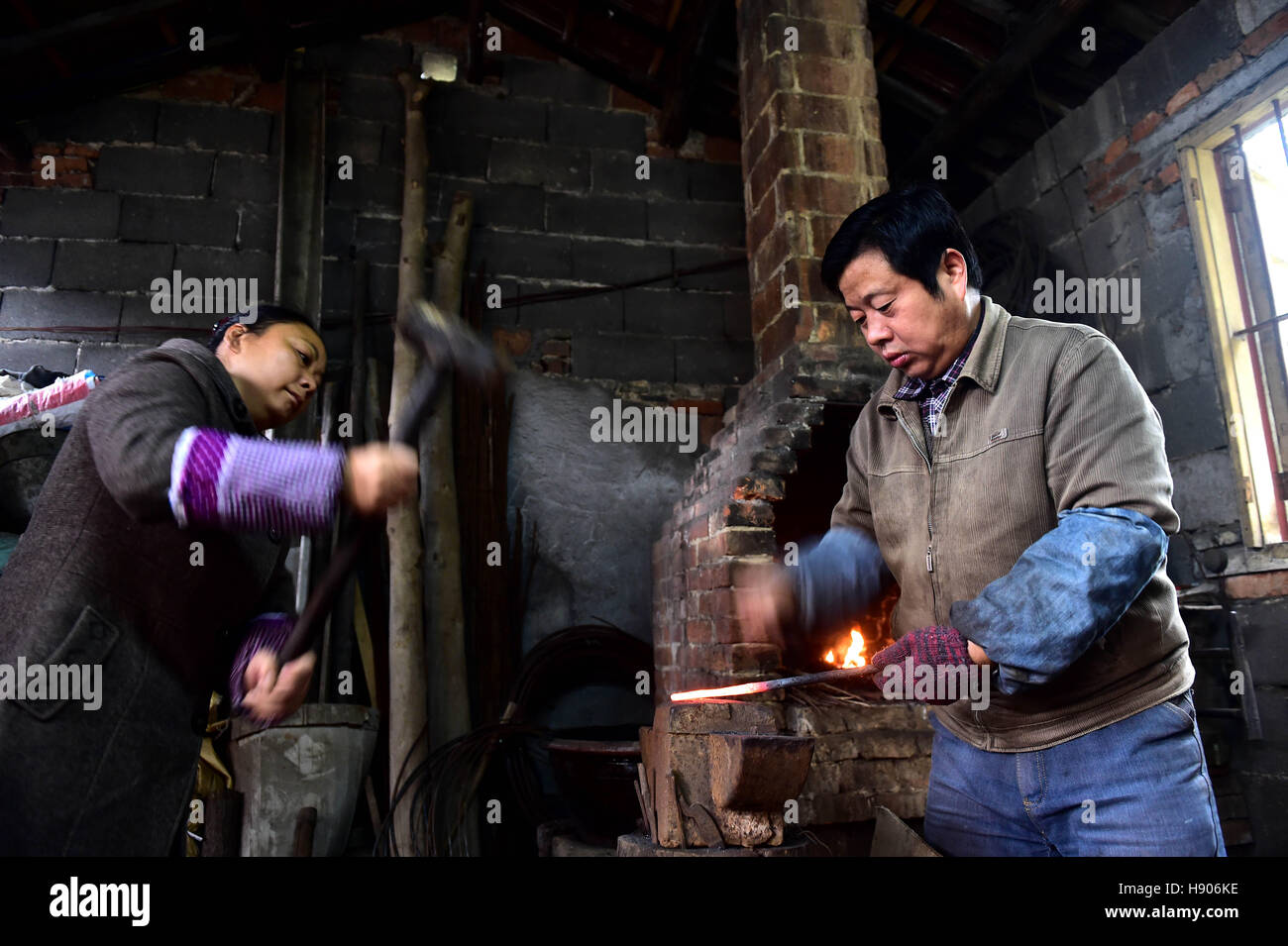 (161117)--JINGXIAN, 17. November 2016 (Xinhua)--Yu Songtao und seine Frau schlug die Bewehrung für die Herstellung von Schere in Houshan Dorf unter Dingjiaqiao Stadt Jingxian County, der ostchinesischen Provinz Anhui, 17. November 2016. Yu Songtao, die Erbin der Technik der Schere Produktion in Houshan Dorf leistet Schere seit 35 Jahren seit er 15 Jahre alt war. Es gibt über 80 Verfahren bei der Herstellung der Schere. Yu ist nur ein Dutzend von ihnen jeden Tag wegen der komplizierten Handwerk möglich. Er wünscht sich, dass mehr Menschen über die Technik so, dass dieser immateriellen erfahren kulturellen Welterbe Stockfoto