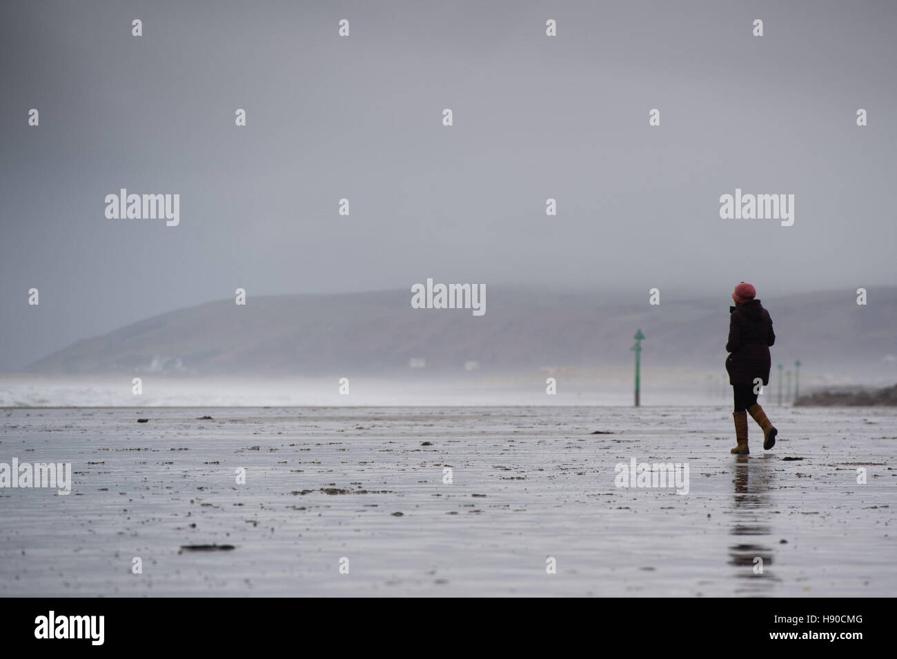 Borth, Cardigan Bay, Ceredigion, Wales UK. Dienstag, 10. Januar 2017 UK Wetter: eine Frau zu Fuß am Strand von Borth im Westen Wales Küste an einem stürmischen bewölkten Tag. Die Wettervorhersage für die nächsten 25 Stunden ist für immer stärkere Winde über viel im Westen des Vereinigten Königreichs, und Schnee bis zum Wochenende Credit ankommen: Keith Morris/Alamy Live-Nachrichten Stockfoto