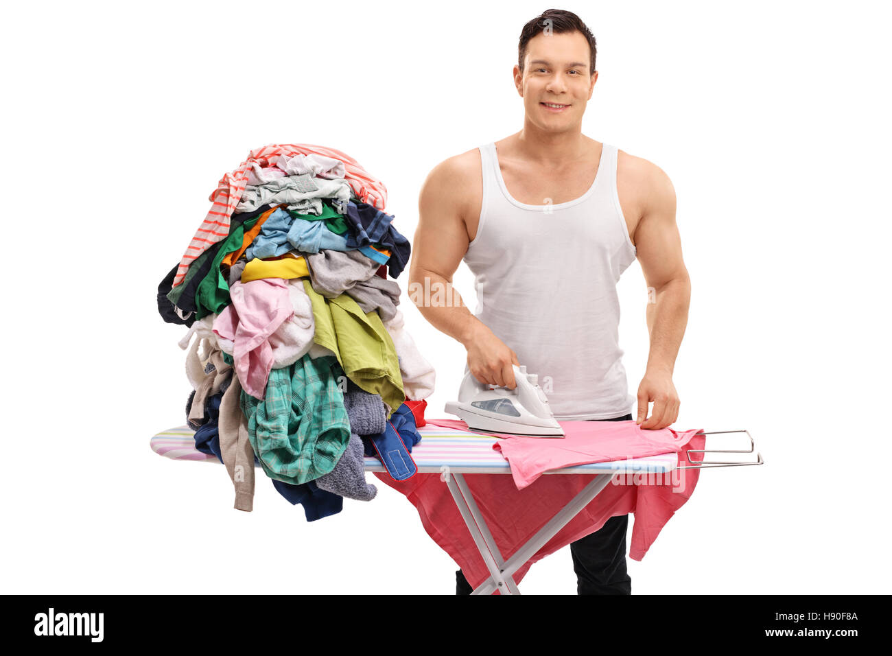 Freudige muskulösen Kerl Bügeln einen Haufen Kleider isoliert auf weißem Hintergrund Stockfoto