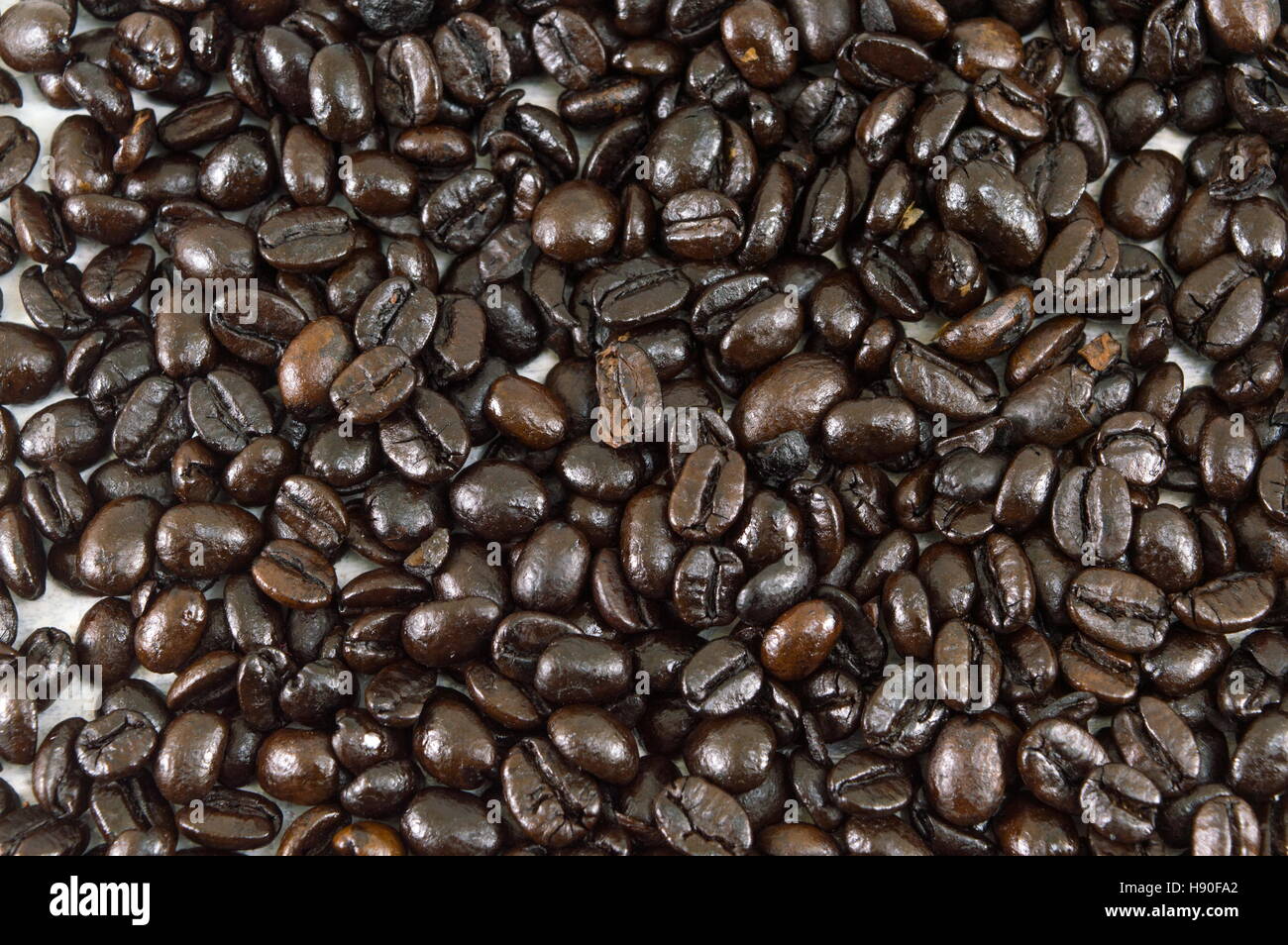 Handvoll geröstete Kaffeebohnen bilden Hintergrund Stockfoto
