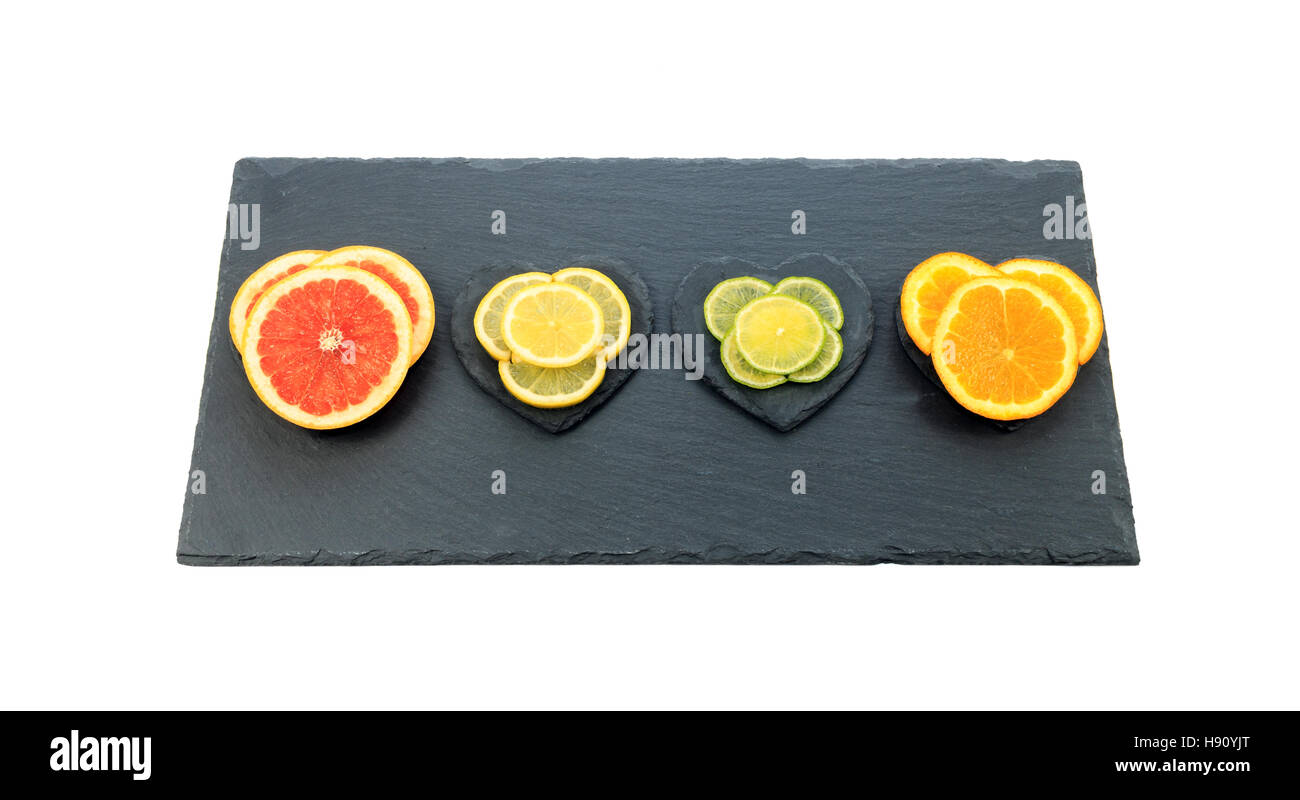 In Scheiben geschnitten Zitrusfrüchten orange, Schiefer rosa Grapefruit, Zitrone und Limette auf schwarzem Board isoliert auf weißem Hintergrund Stockfoto