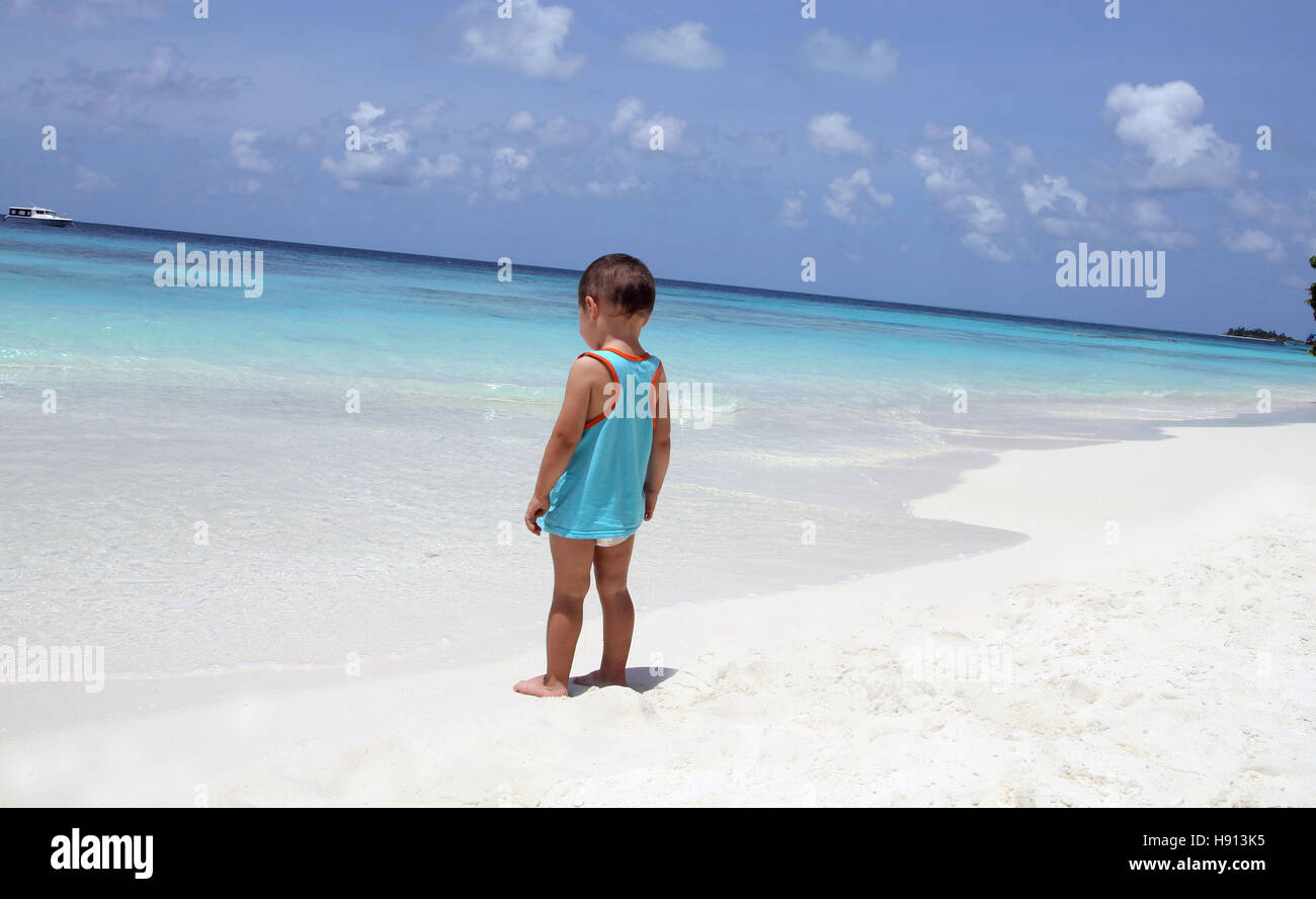 3 Jahre altes Kind suchen am Strand auf den Malediven Insel weißen Sand blau des Ozeans Stockfoto