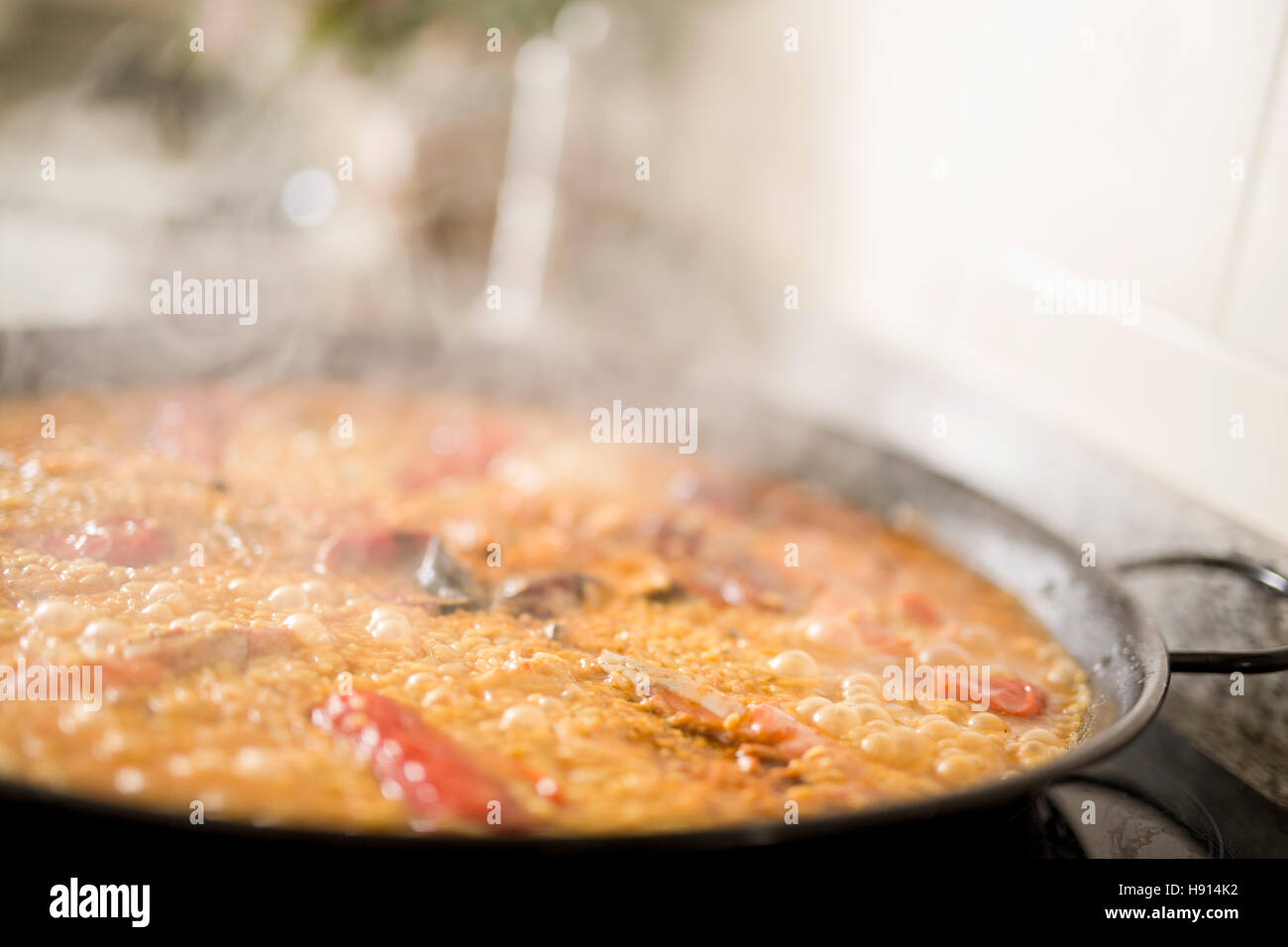 Paella Kochen auf einem Elektroherd. Typische Küche der valencianischen Gemeinschaft in Spanien Stockfoto
