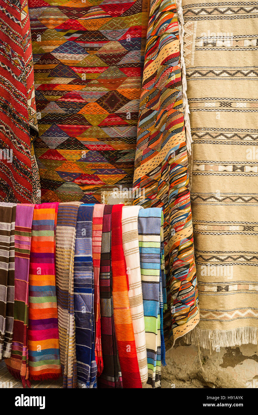 Teppiche, Teppiche und Schals angezeigt außerhalb der Shop im Souk, Essaouira, Marokko Stockfoto