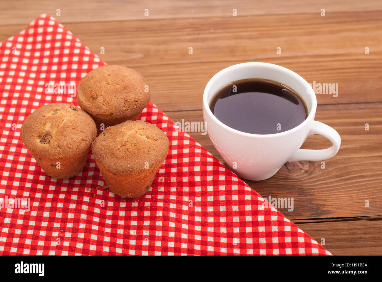 Tasse Kaffee und Kuchen auf einem Holztisch. Stockfoto