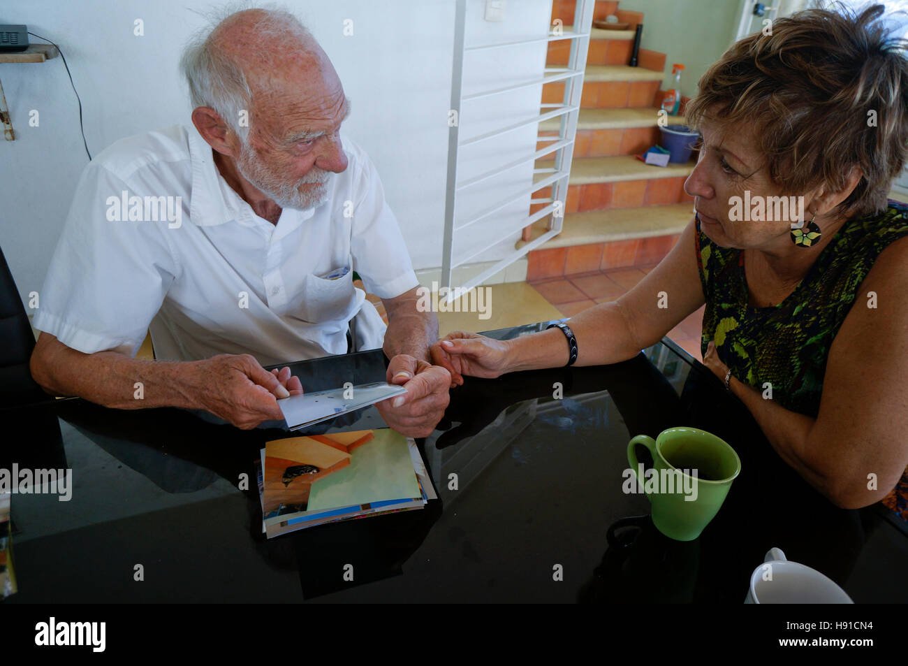Älterer Mann mit Blick auf Fotos von Familie und Urlaub. Stockfoto