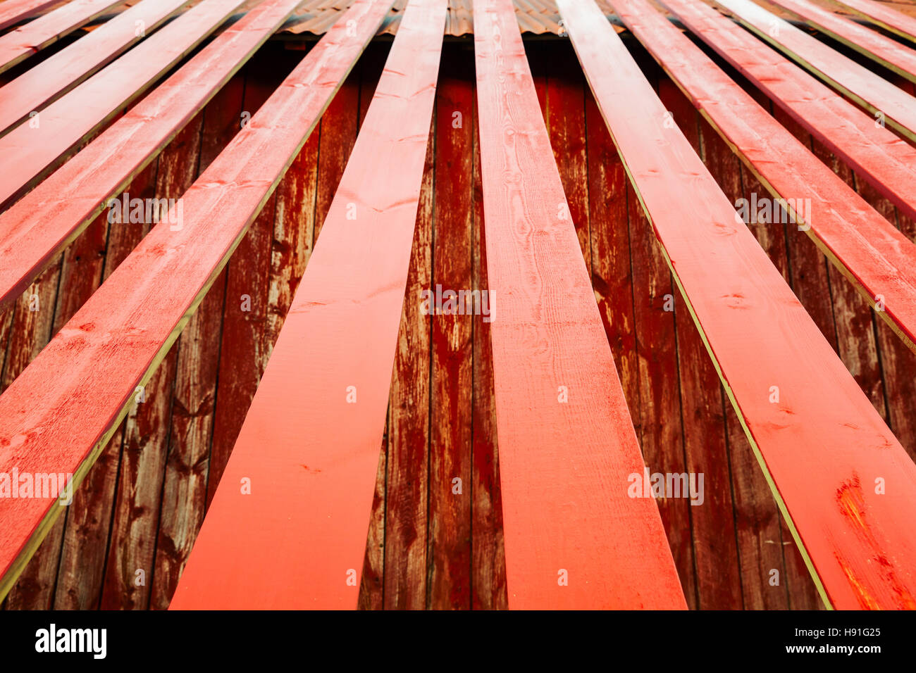 Frische rote lackierte Holzbretter sind in der Nähe von ländlichen norwegischen Scheune, Fotohintergrund mit perspektivische Wirkung und selektiven Fokus trocknen Stockfoto