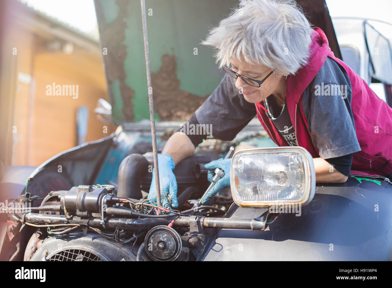 Ältere Kfz-Mechaniker arbeitet an ihrem Oldtimer Stockfoto