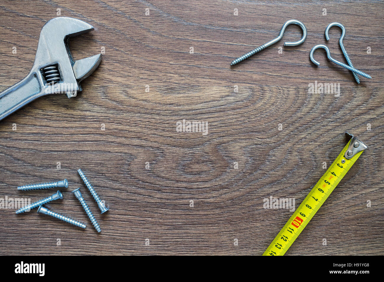 Verschiedene Werkzeuge (Schraubenschlüssel, Lineal, Schrauben) auf einem hölzernen Hintergrund. Väter-Tageskarte mit Textfreiraum. Stockfoto