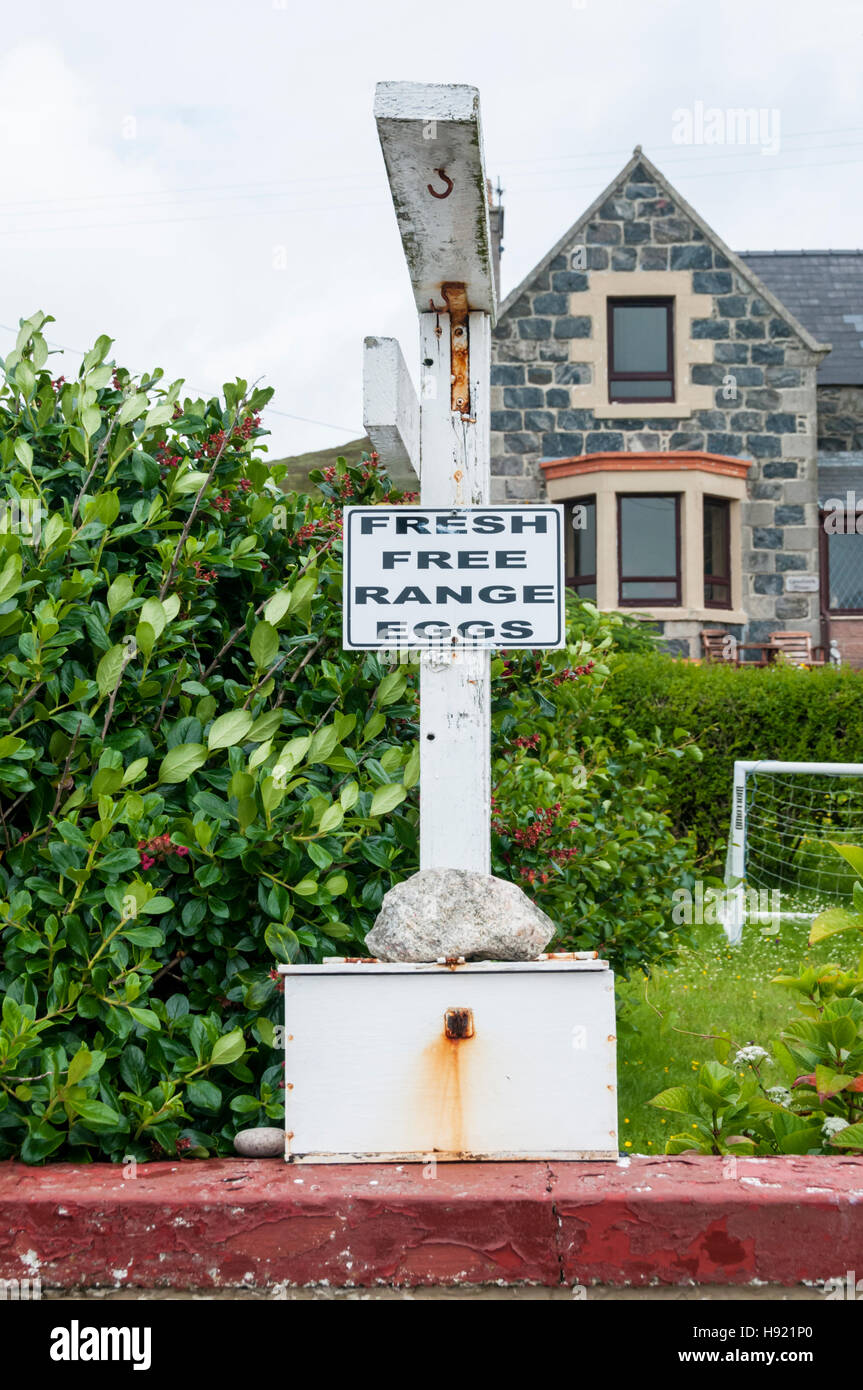 Ein kostenloses Angebot Frischeier Zeichen mit einer Ehrlichkeit Box vor einem Haus in den äußeren Hebriden. Stockfoto