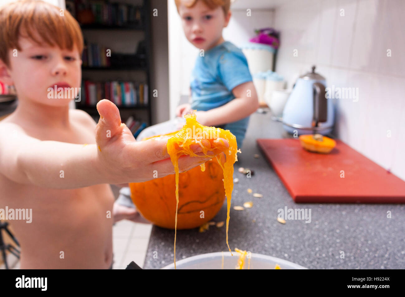 Kaukasische junge carving einen Kürbis für Halloween in einer Küche Stockfoto