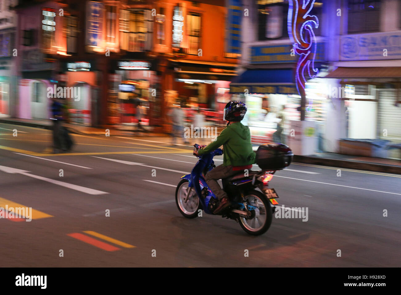 Einsame Motorradfahrer fährt durch die Stadt. Stockfoto