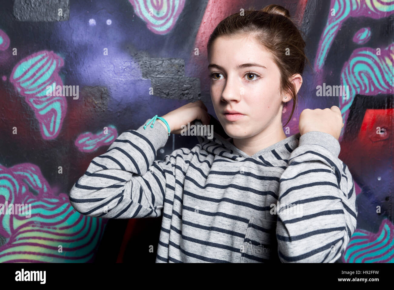 Porträt eines jungen Mannes mit Jersey Streifen auf einem Hintergrund mit Graffiti bemalt. Stockfoto