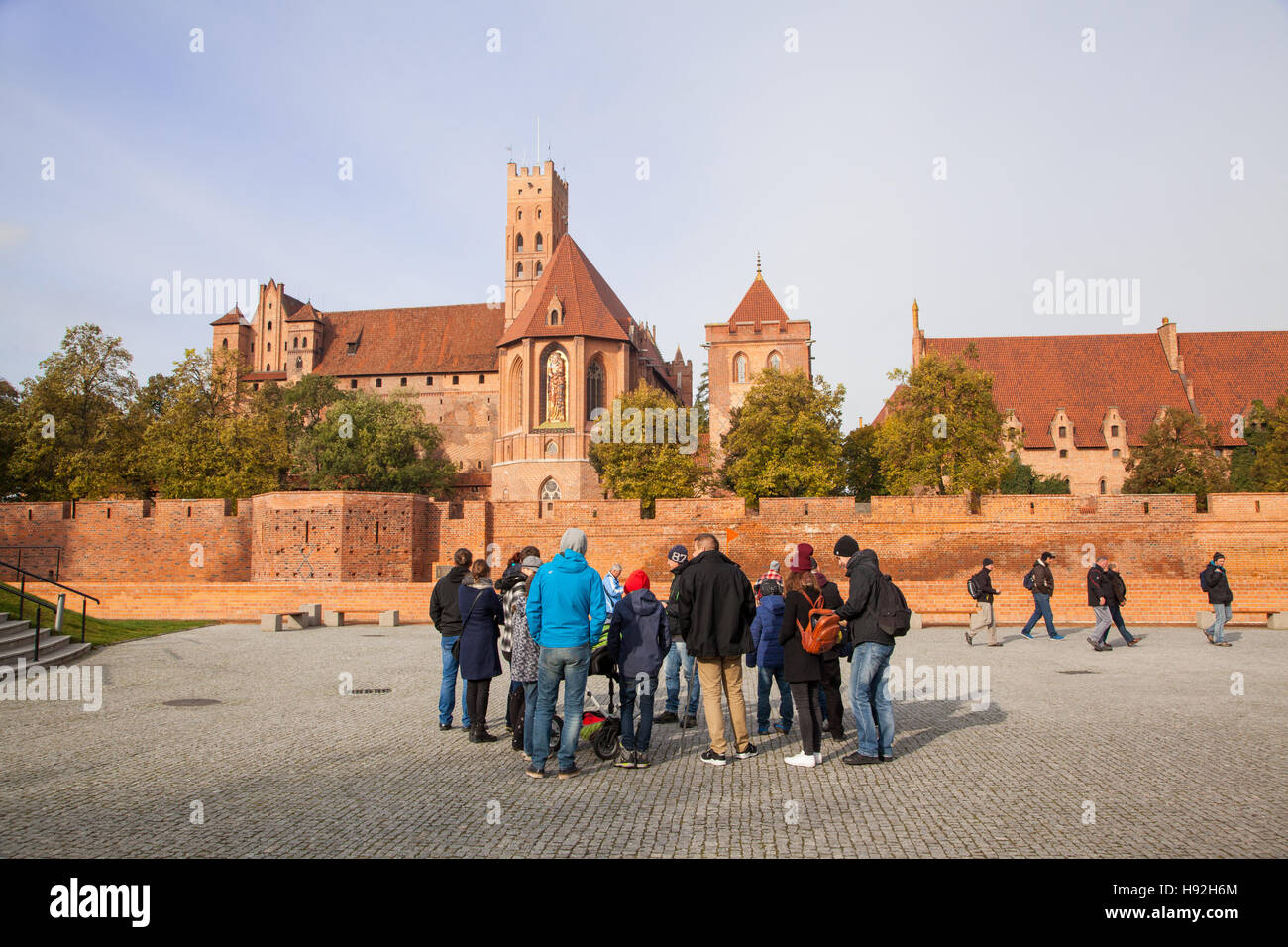 Touristen vor dem mittelalterlichen Schloss in Marienburg Polen stehen auf dem Fluss Nogat, erbaut von den Rittern des Deutschen Ordens Stockfoto