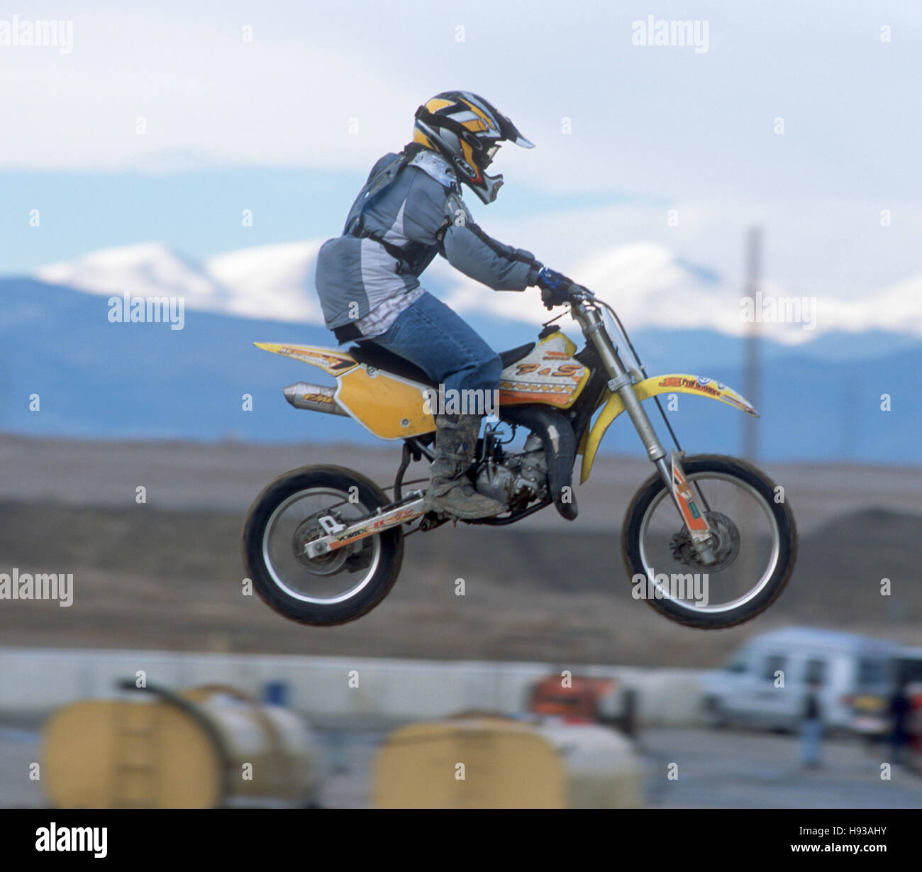 Junge Schmutz Biker macht einen Sprung mit den Rocky Mountains im Hintergrund. Stockfoto