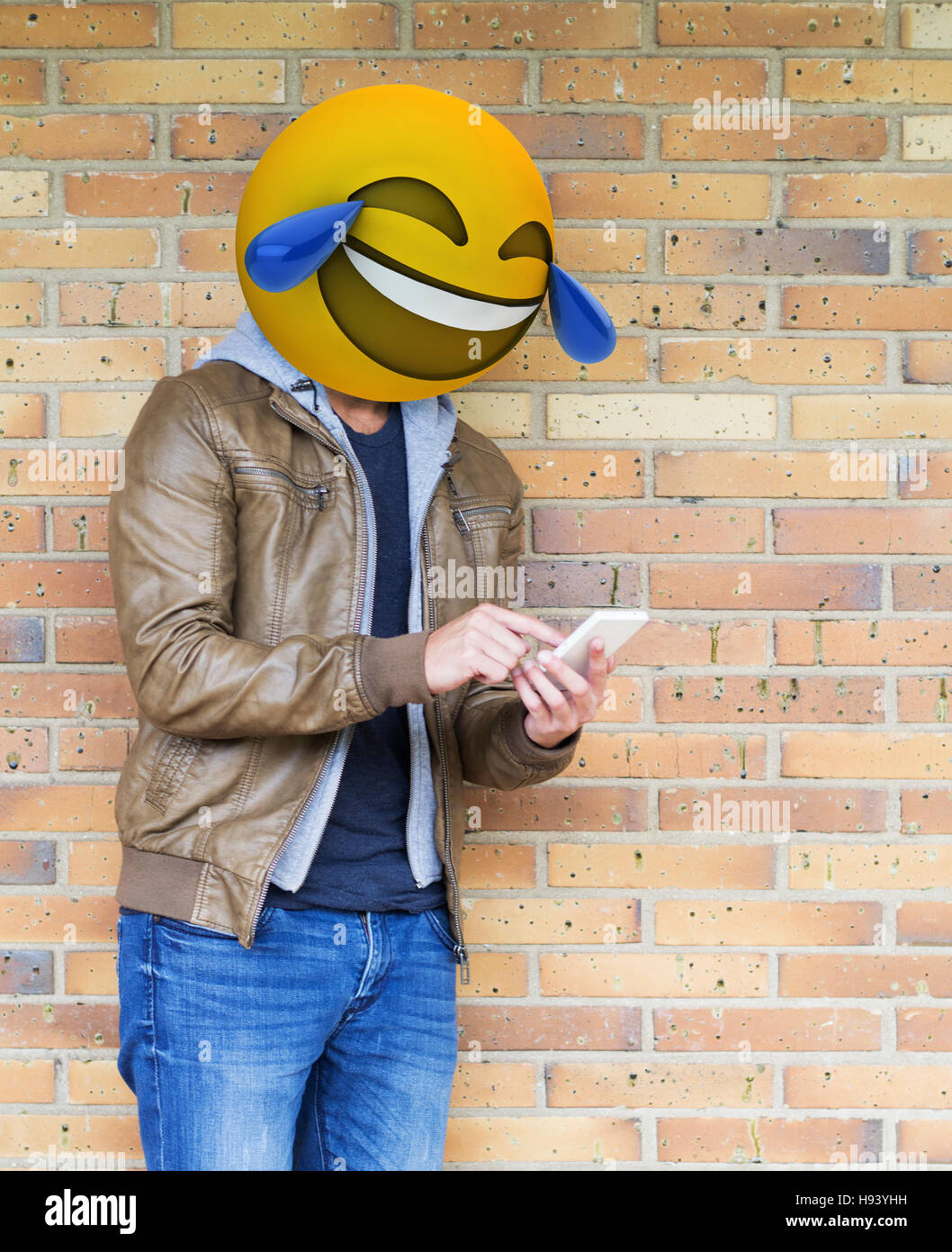 Emoji Kugelkopf Mann auf seinem Smarphone und lachen Stockfoto