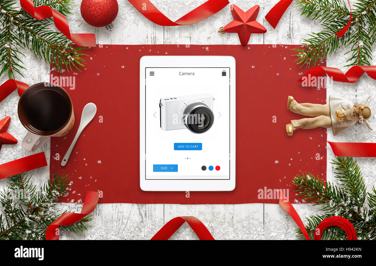 Shopping mit Tablet auf e-Commerce-Website. Weihnachtszeit. Draufsicht der Tabelle mit Weihnachtsschmuck. Stockfoto