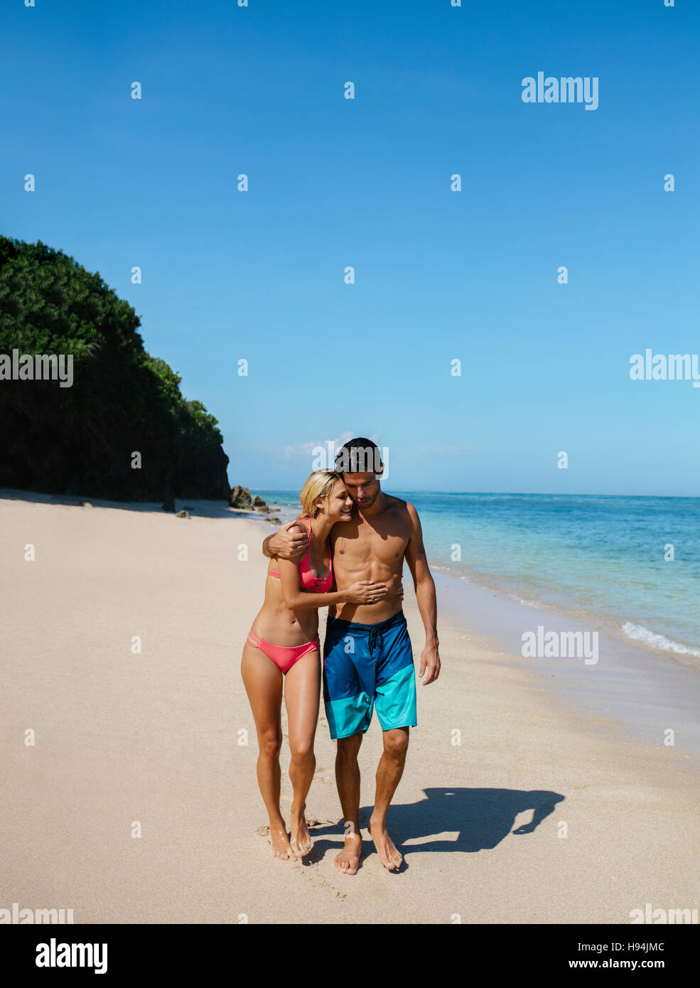 Aufnahme des jungen Mann und Frau zu Fuß auf den tropischen Strand. Romantisch zu zweit spazieren am Strand, Sommerurlaub genießen. Stockfoto