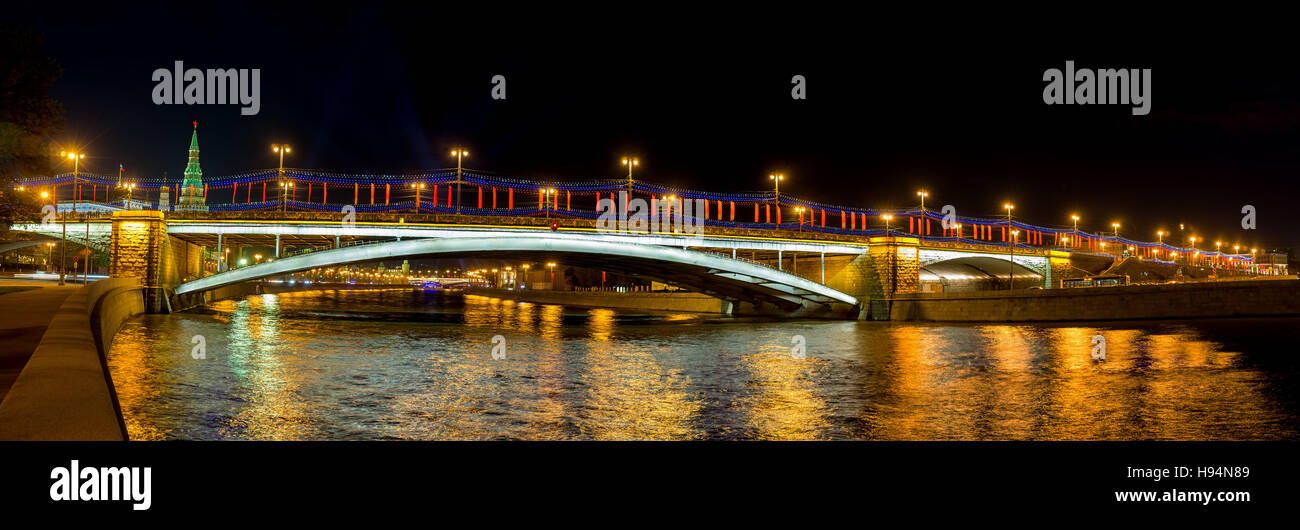 Der Blick vom Prechistenskaya Ufer des Moskwa-Flusses auf größere Steinbrücke Abendhelle Lichter, die im dunklen Wasser, Moskau Stockfoto