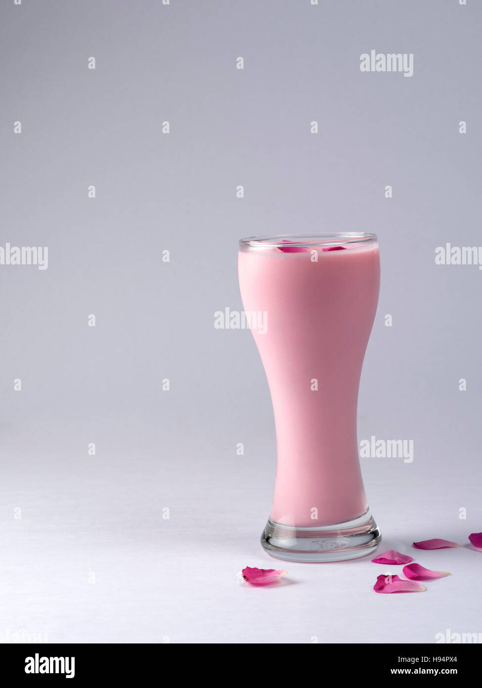 ROSE-SMOOTHIE, SERVIERT IN EINEM GLAS AUF WEIßEM HINTERGRUND Stockfoto
