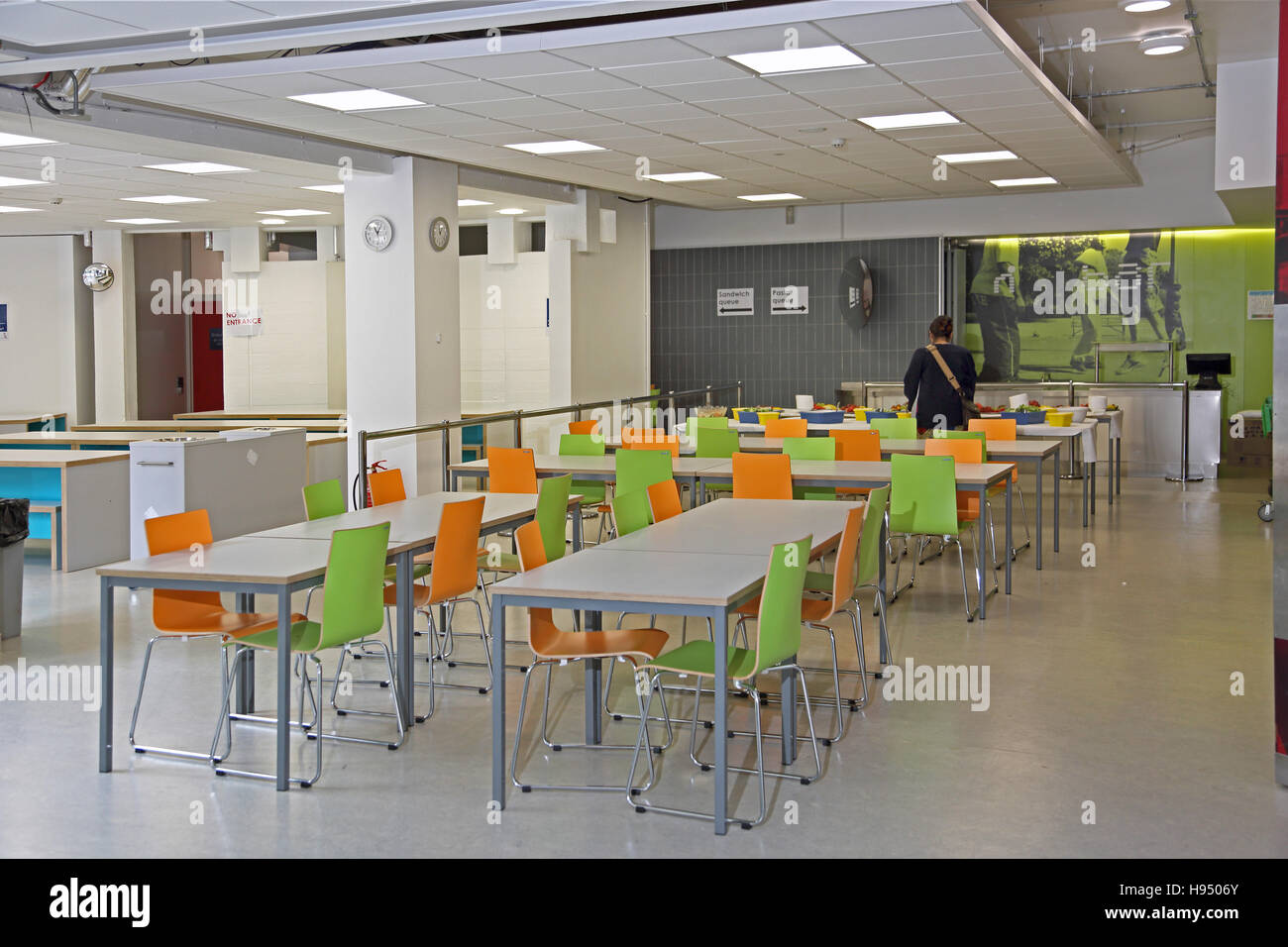 neu renovierte Schule Speisesaal machte sich mit weißen Tische und Stühle Orange und Lime grün Holz Stockfoto