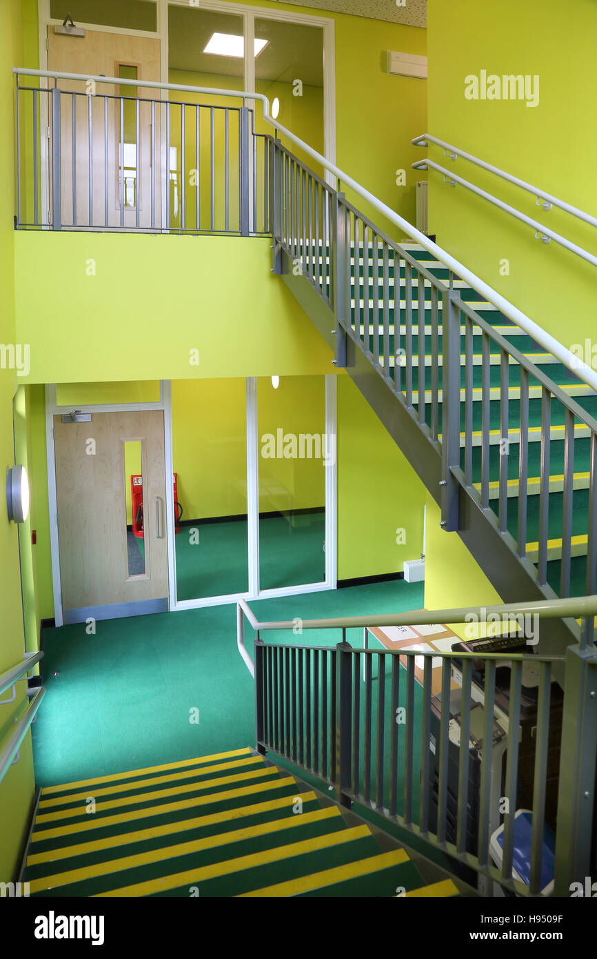 Stahltreppe in eine neue Schule Klassenzimmer Block mit Modulbauweise konstruiert. Markante grüne Wände und Teppich. Stockfoto