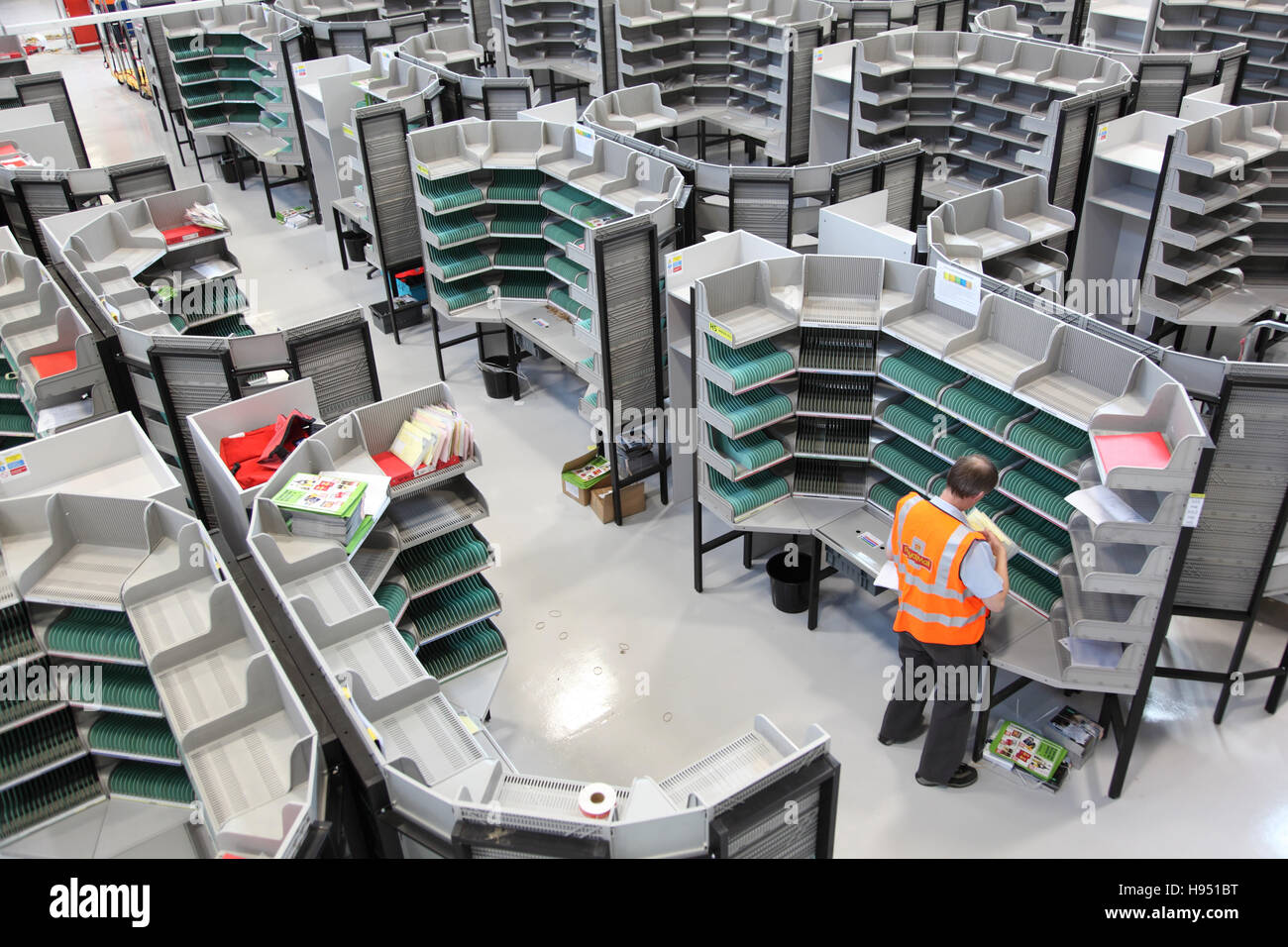 Ein einzelnes Postbote arbeitet an einem Sortierung Schreibtisch in ein neues Postamt Sortierung Büro im südlichen England, UK Stockfoto