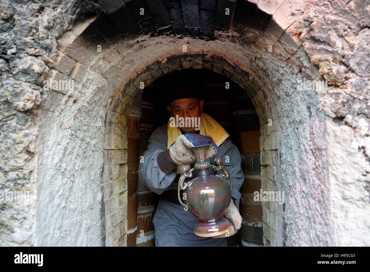 Zhengzhou, China Henan Provinz. 19. November 2016. Eine Mitarbeiter Arbeitskraft nimmt eine Jun-Ware aus der Alge im Rahmen einer Feierstunde die Porzellane aus den Brennofen in Shenhou Township von Jahren Stadt, Zentral-China Henan Provinz, 19. November 2016. Jun-Porzellan ist berühmt für seine erstaunliche Veränderung der Farbe während des Prozesses der Brand in Brennöfen. Shenhou, eine antike Stadt in bergigen Gegend von Henan, schon seit langem für die Herstellung von Jun Porzellan. © Li ein/Xinhua/Alamy Live-Nachrichten Stockfoto