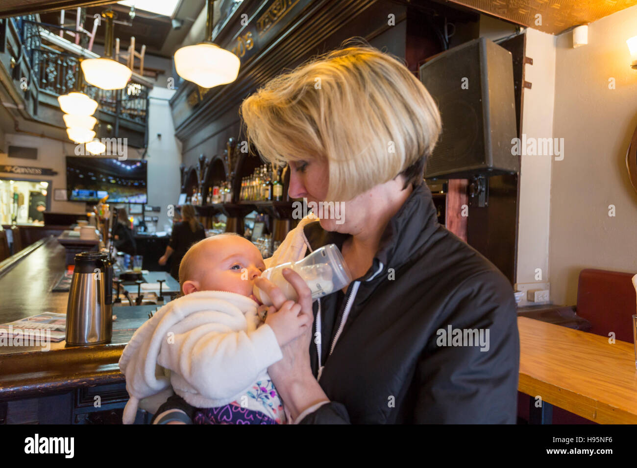 Mutter mit der Flasche füttern 5 Monate altes Baby Mädchen im restaurant Stockfoto