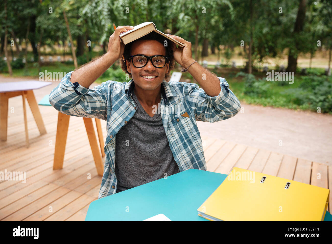 Glücklich afrikanischen jungen Mann in Gläsern zu studieren und Spaß an outdoor-café Stockfoto