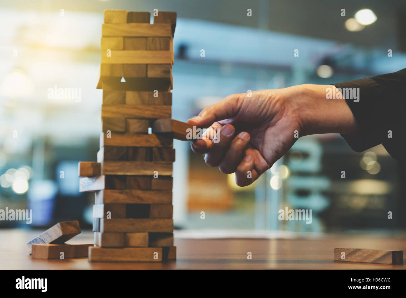 Planung, Risiko und Strategie in der Wirtschaft, Geschäftsmann Glücksspiel Platzierung Holzblock auf einem Turm - Unschärfe für Hintergrund Stockfoto