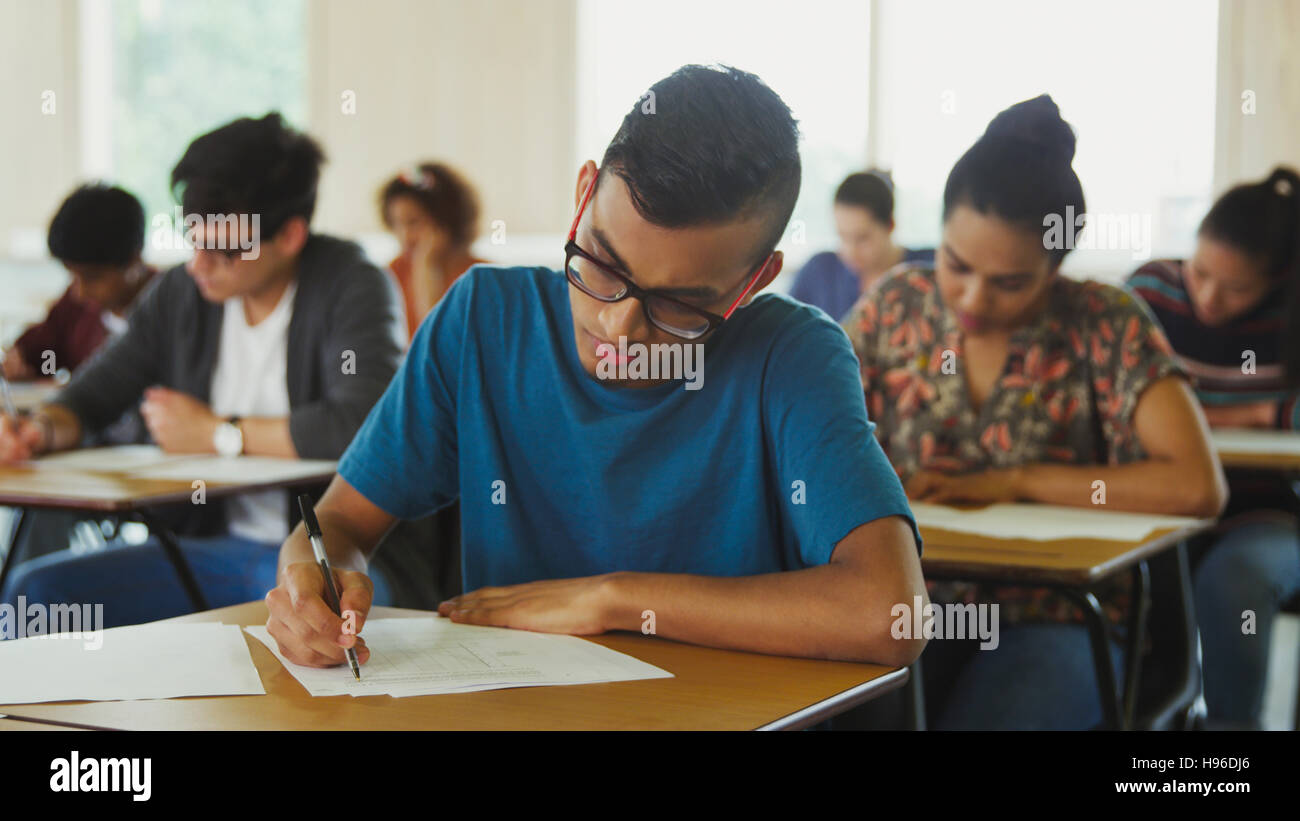 Männliche College-Student unter Test am Schreibtisch im Klassenzimmer Stockfoto