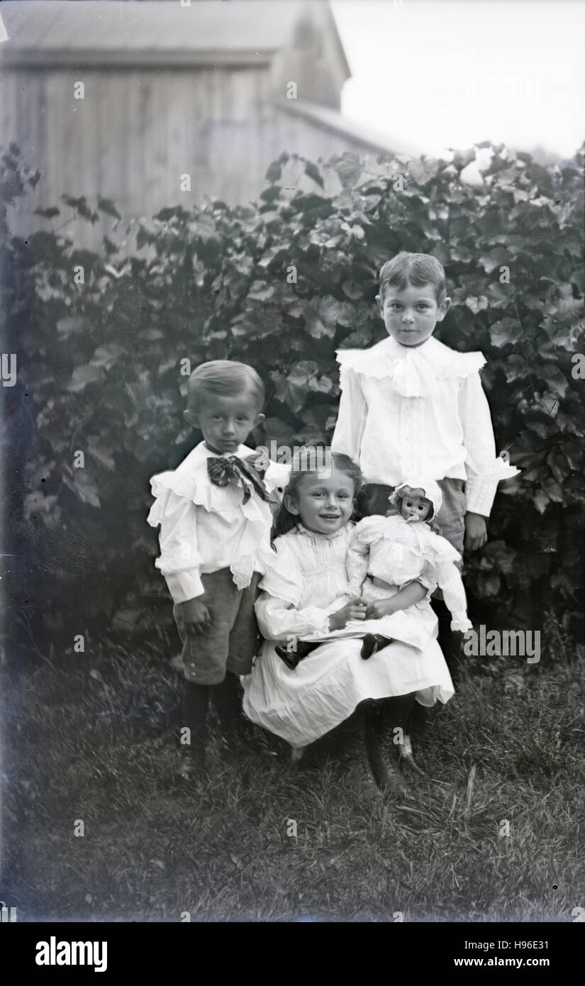 Antike c1890 Foto, Geschwister mit Puppe. Lage unbekannt, wahrscheinlich Midwest (Indiana und Ohio) USA. QUELLE: ORIGINAL FOTONEGATIV. Stockfoto