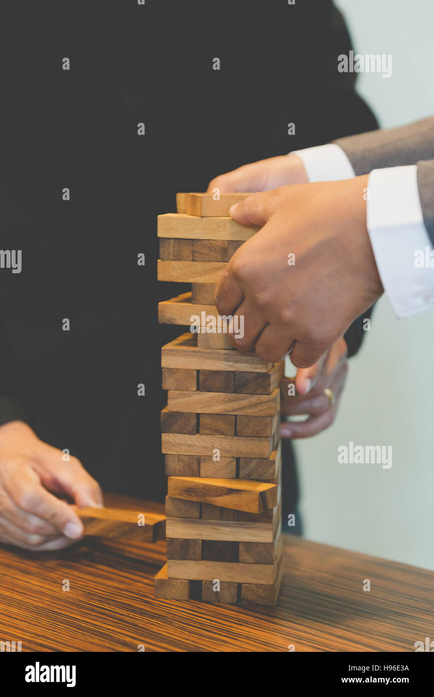 Planung, Risiko und Strategie in der Wirtschaft, Geschäftsmann Glücksspiel Platzierung Holzblock auf einem Turm - Unschärfe für Hintergrund Stockfoto