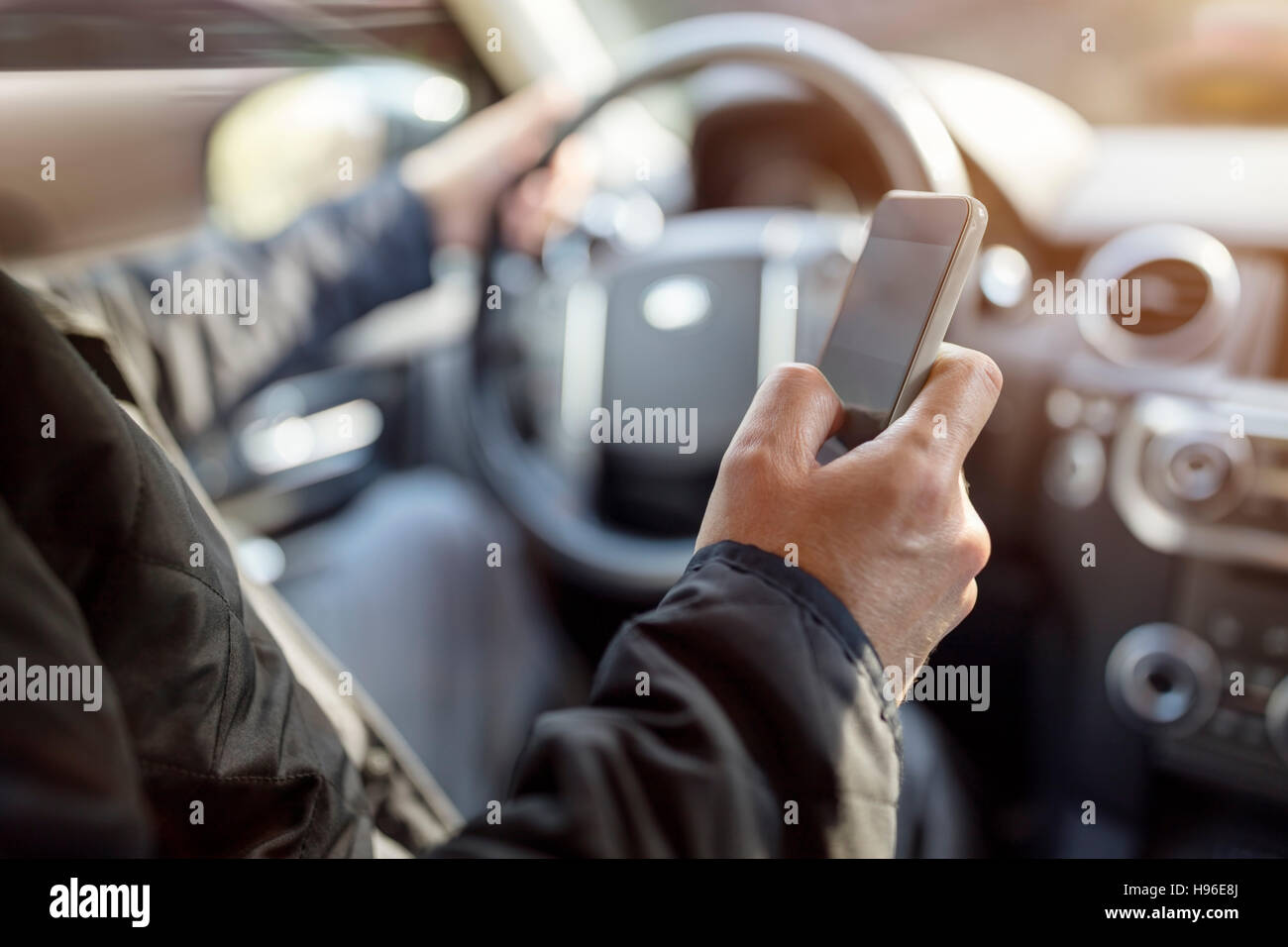 SMS während der Fahrt mit Handy im Auto Stockfoto