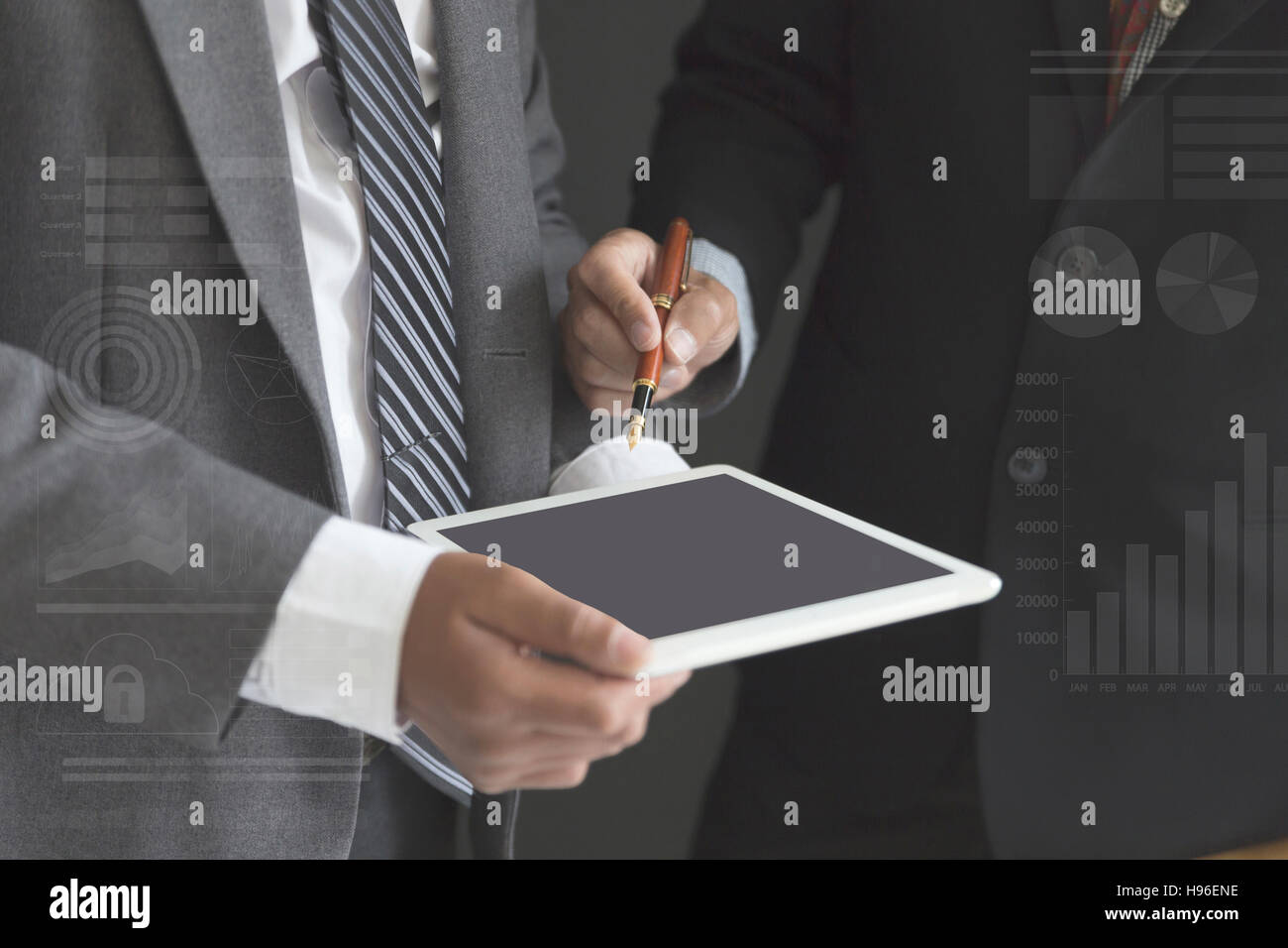 zwei Geschäftsleute im Anzug zu diskutieren und analysieren Geschäftsstrategie mit tablet Stockfoto