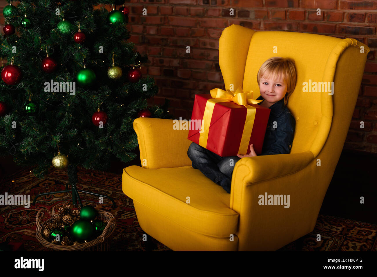 Das Kind mit einem Geschenk in der Nähe von the Christmas tree Stockfoto