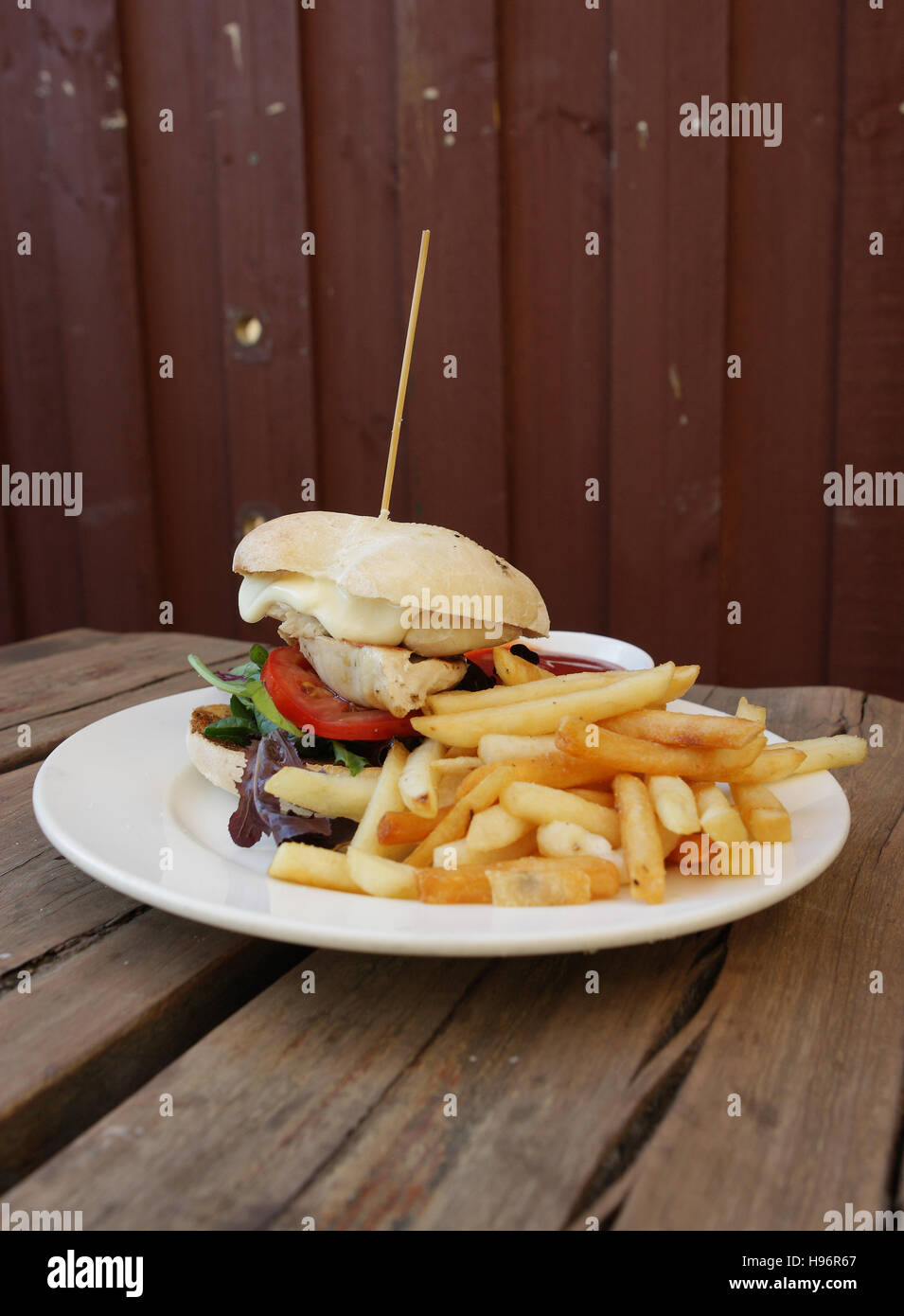 Hamburger mit Pommes Frites und Ketchup, rustikalen Holztisch, Fast-food Stockfoto
