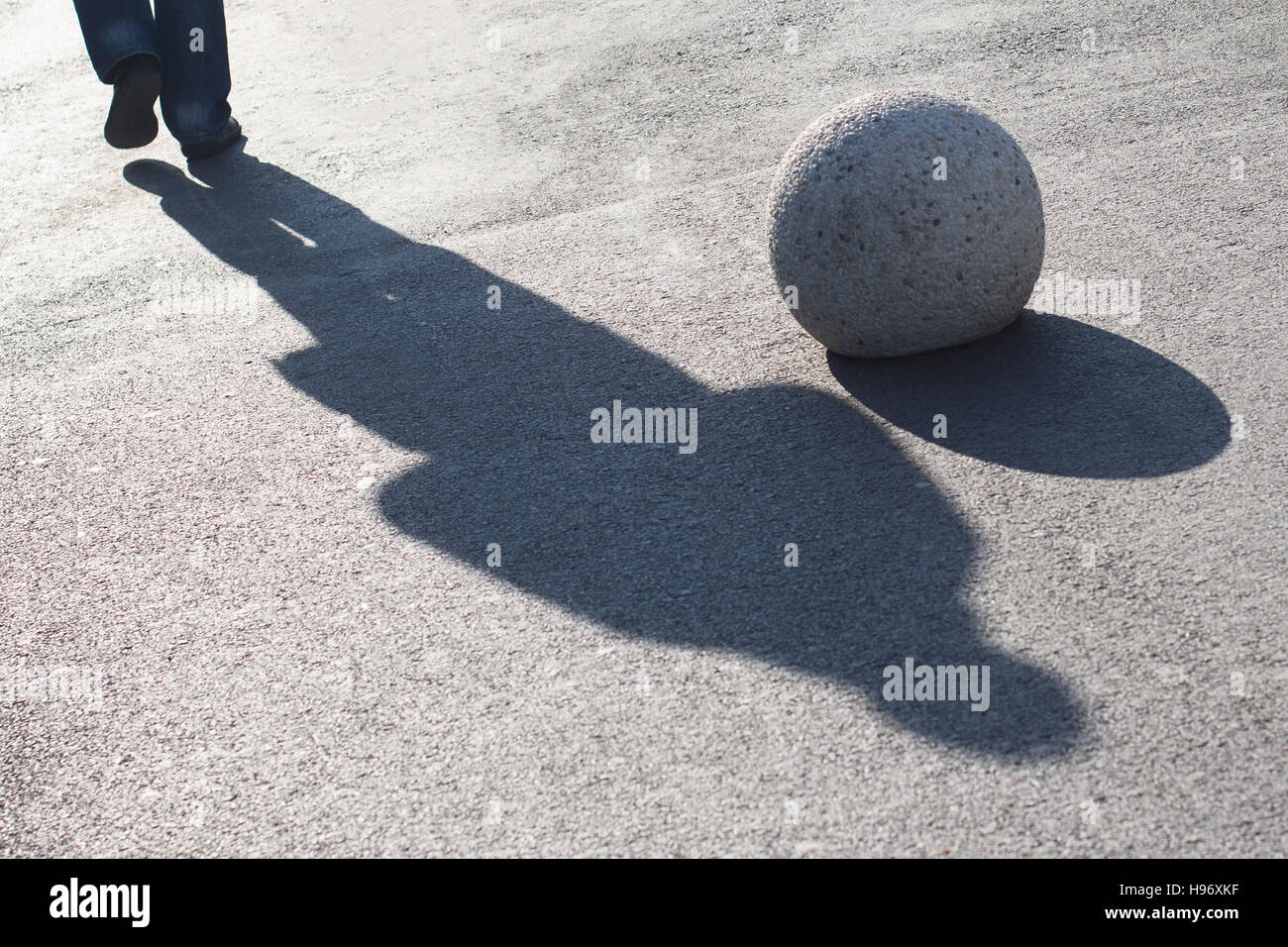 Schatten von einem Mann auf der Straße Bürgersteig eine Runde dekorative Bürgersteig Stein vorbei Stockfoto