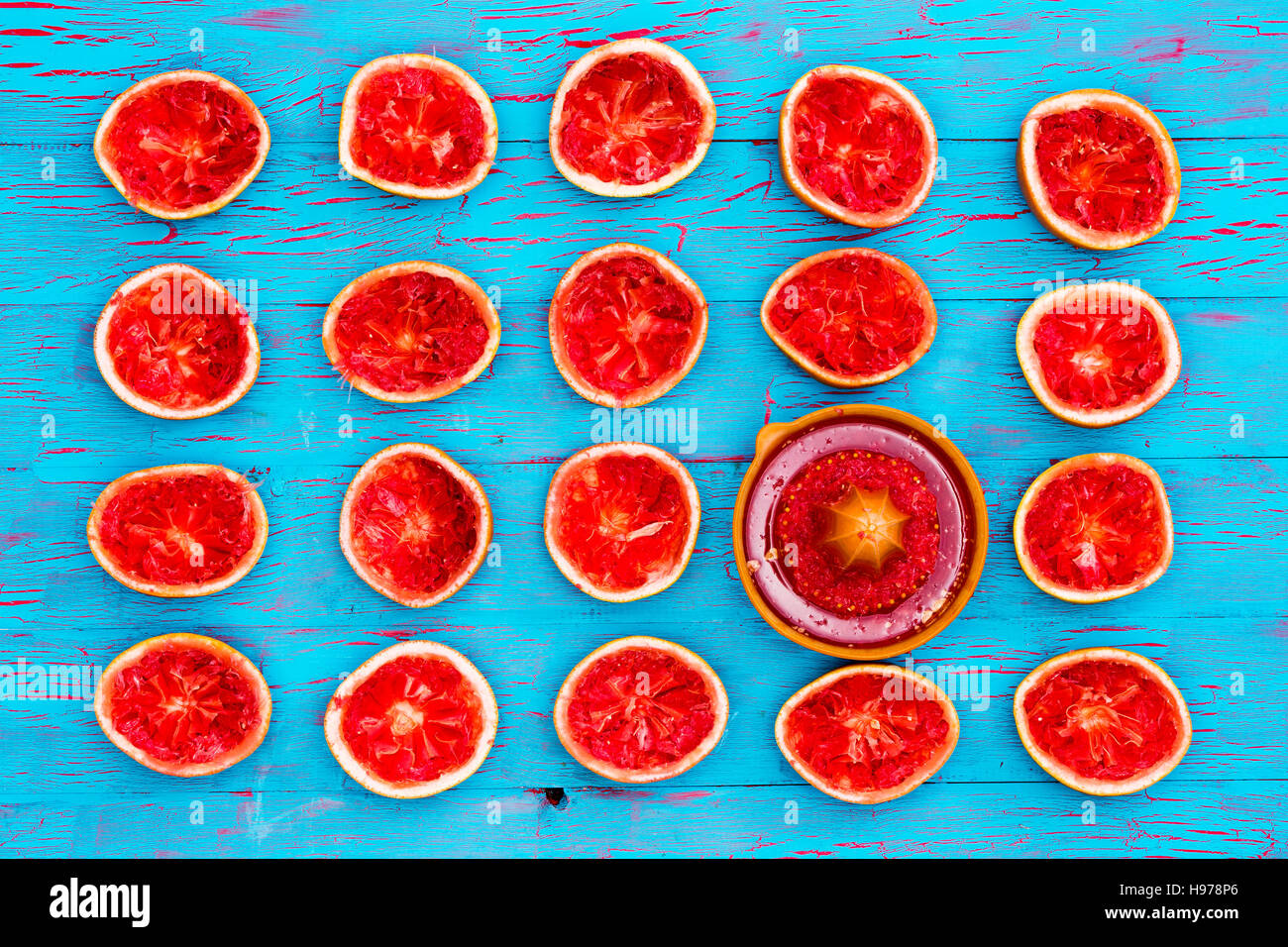 Frisch gepresster Ruby Grapefruit Hälften reich an Pektin lö € gslichen Ballaststoffen auf einen exotischen blau Crackle Lack Tisch mit eine manuelle Saftpresse in n von oben gesehen Stockfoto