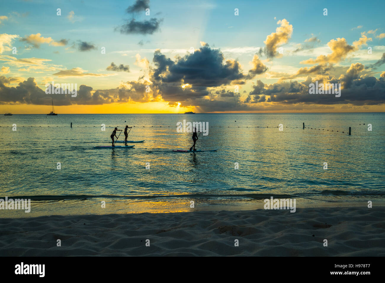 Sonnenuntergang über einem tropischen Meer mit goldenen Himmel und Wolken Stockfoto