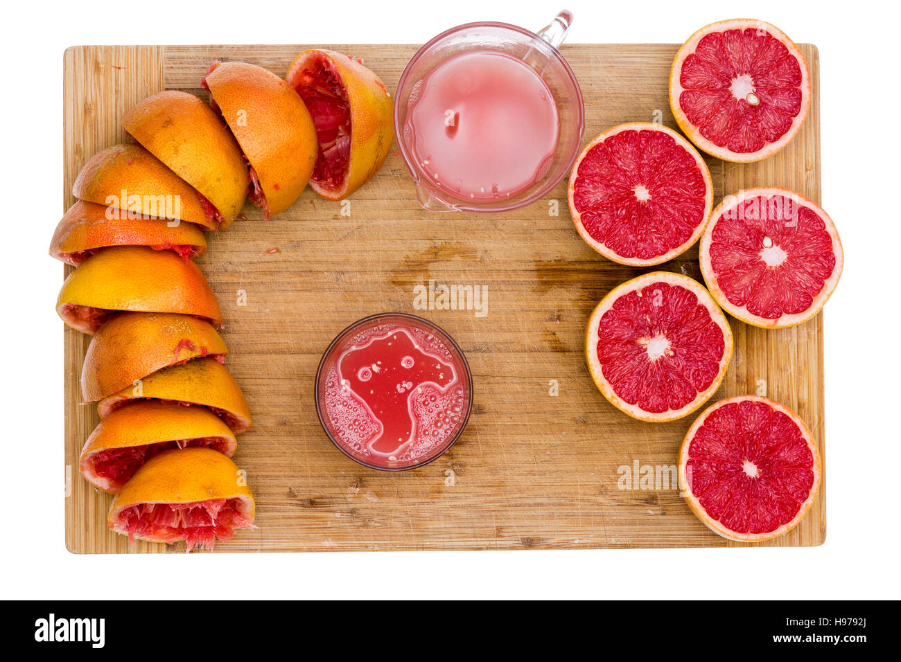 Ruby Grapefruit-Saft mit einer Draufsicht auf einem Bambus-Brett mit leeren Schwarten, saftige halbe Frucht, ein Krug und Glas frisch gepressten frisch vorbereiten Stockfoto
