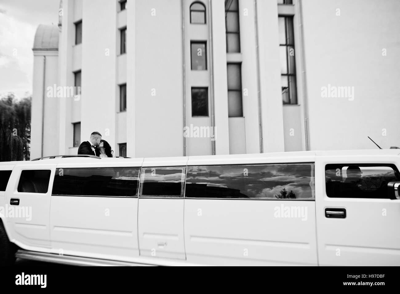 Kiew, Ukraine - 31. August: Eleganz weiße Hochzeit Limousine Hummer H2 mit Brautpaar auf Auto Schiebedach am Hochzeitstag. Schwarz / weiß Foto Stockfoto