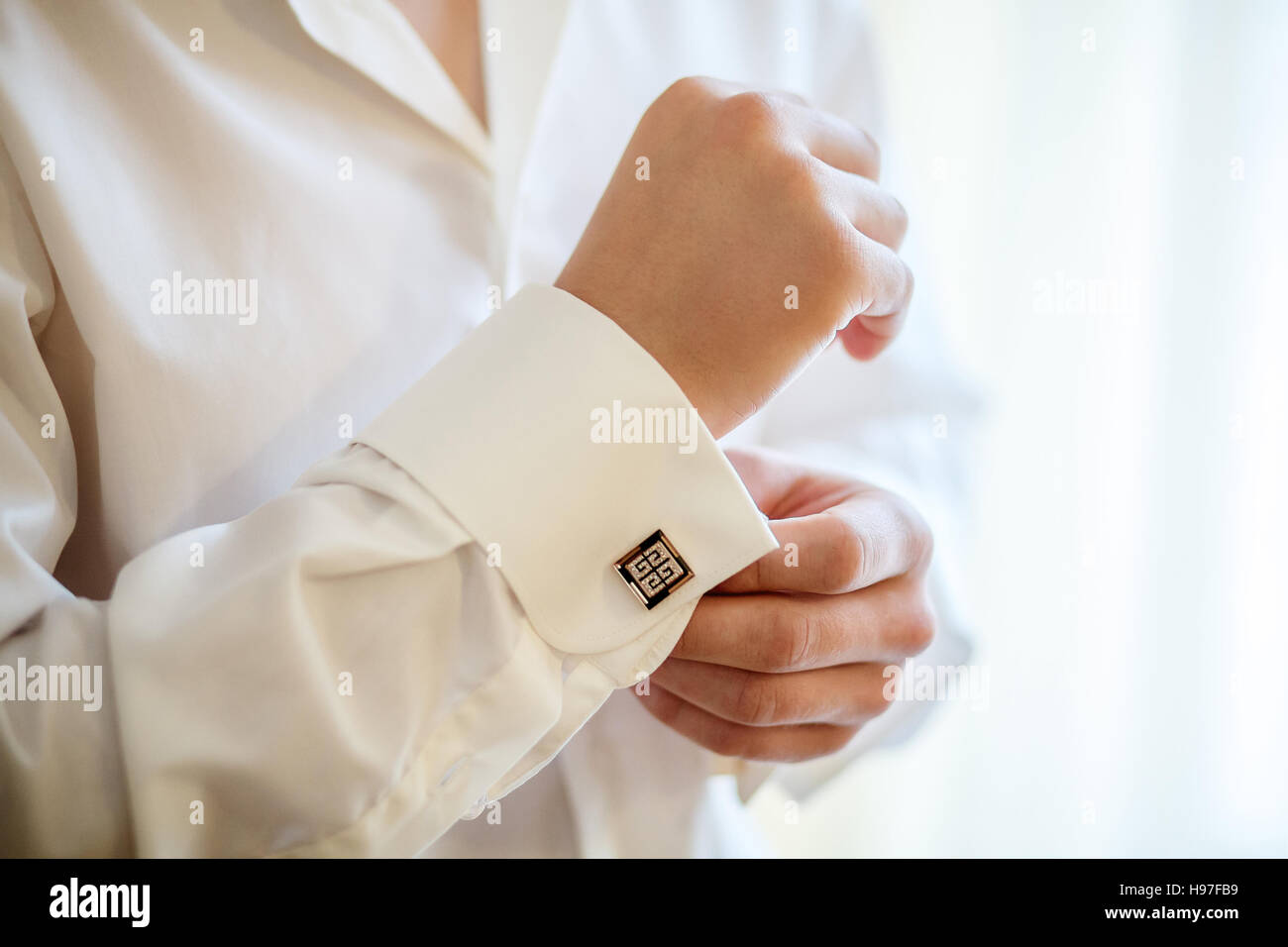 Elegante Mode Mann Festsetzung seiner Manschettenknöpfe, Nahaufnahme Stockfoto