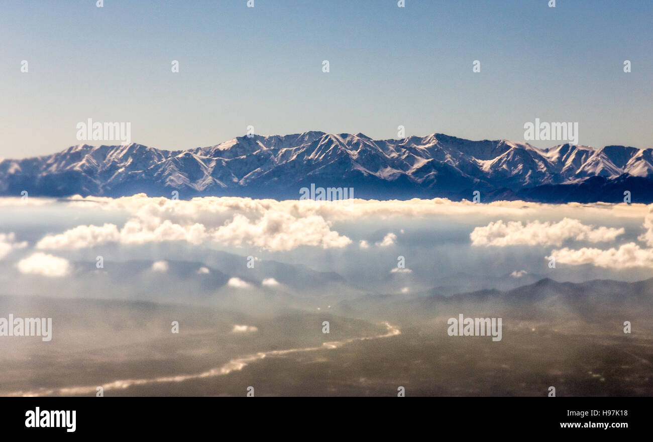 Blick vom Flugzeug auf die Berge und ein Boden unterhalb der Wolke verdoppeln Stockfoto