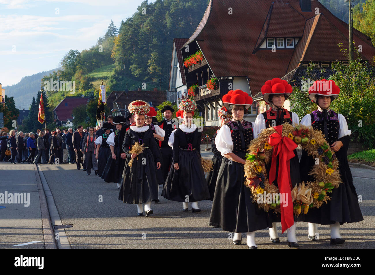 Gutach (Schwarzwaldbahn): Thanksgiving Parade an der Kirche, Frauen mit Bollenhut (Bollen Hut) oder Schäppel Kopf Abdeckung, Schwarzwald, Schwarzwald, Bade Stockfoto