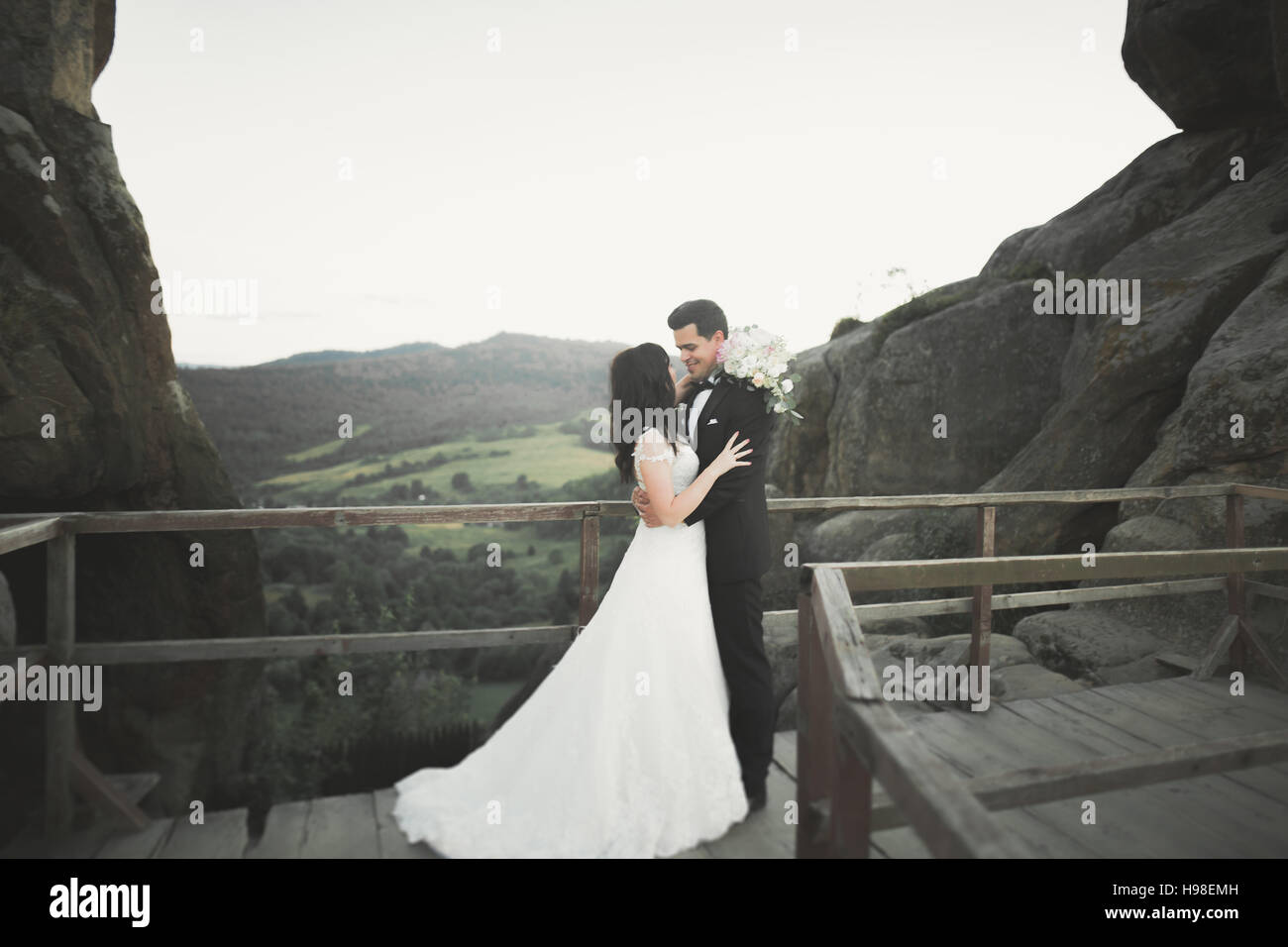 Hochzeitspaar in Liebe küssen und umarmen in der Nähe von Felsen auf schöne Landschaft Stockfoto