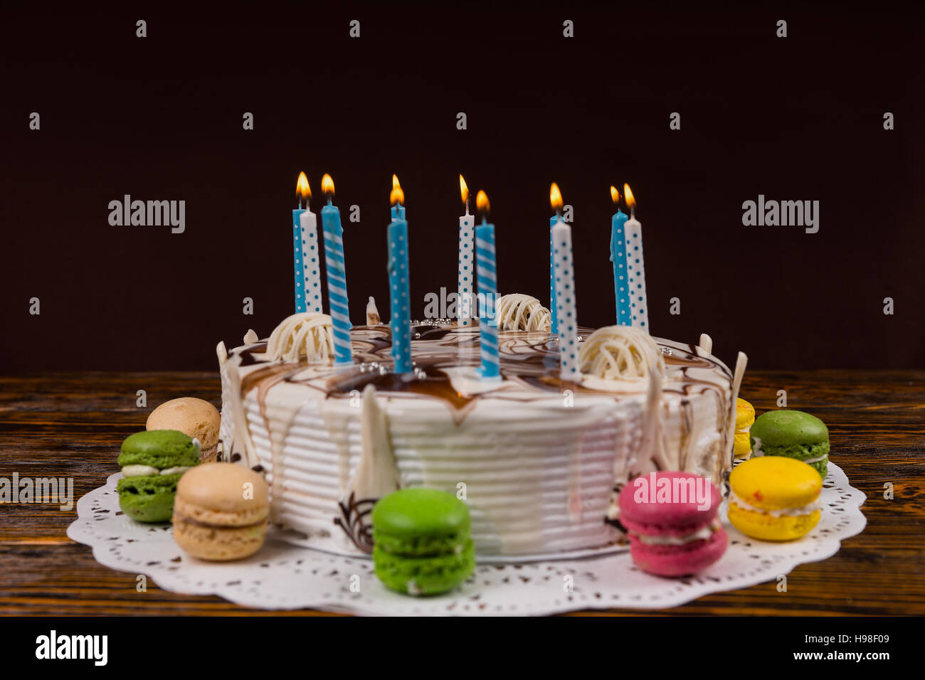 Weiße hausgemachten Geburtstagstorte mit vielen brennenden Kerzen in der Nähe von verschiedenen