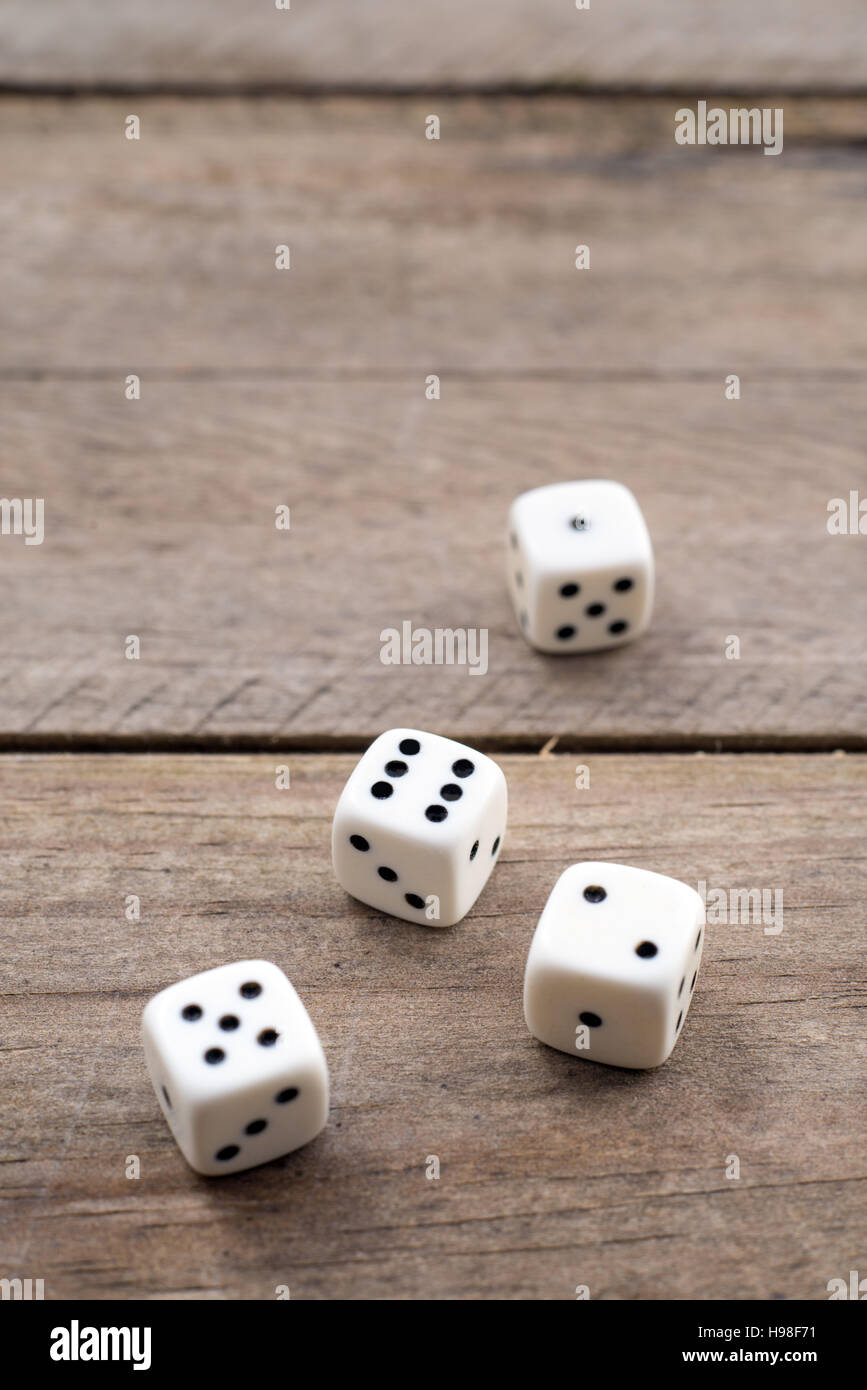Vier weiße Würfel auf hölzernen Hintergrund Stockfoto